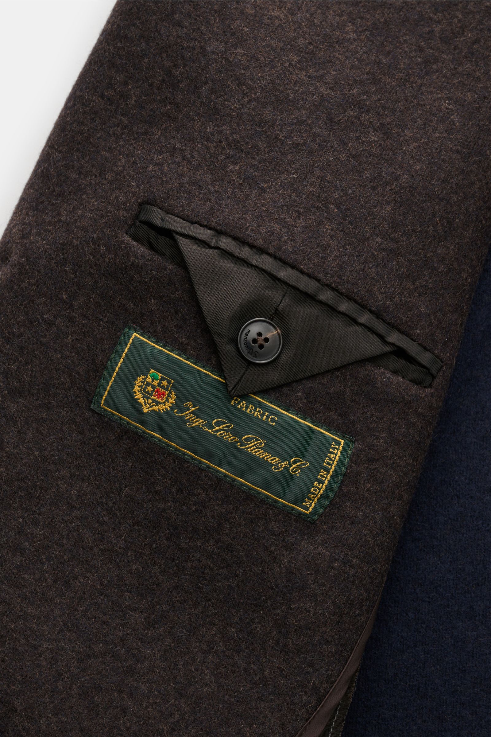 Close-up view of the interior pocket with button and fabric label on the Manzoni 24 Kurzmantel dunkelbraun, showcasing the high-end wool mix by LORO PIANA. The coat features a cashmere and wool blend, soft touch, light quality, slim fit, three-button fron