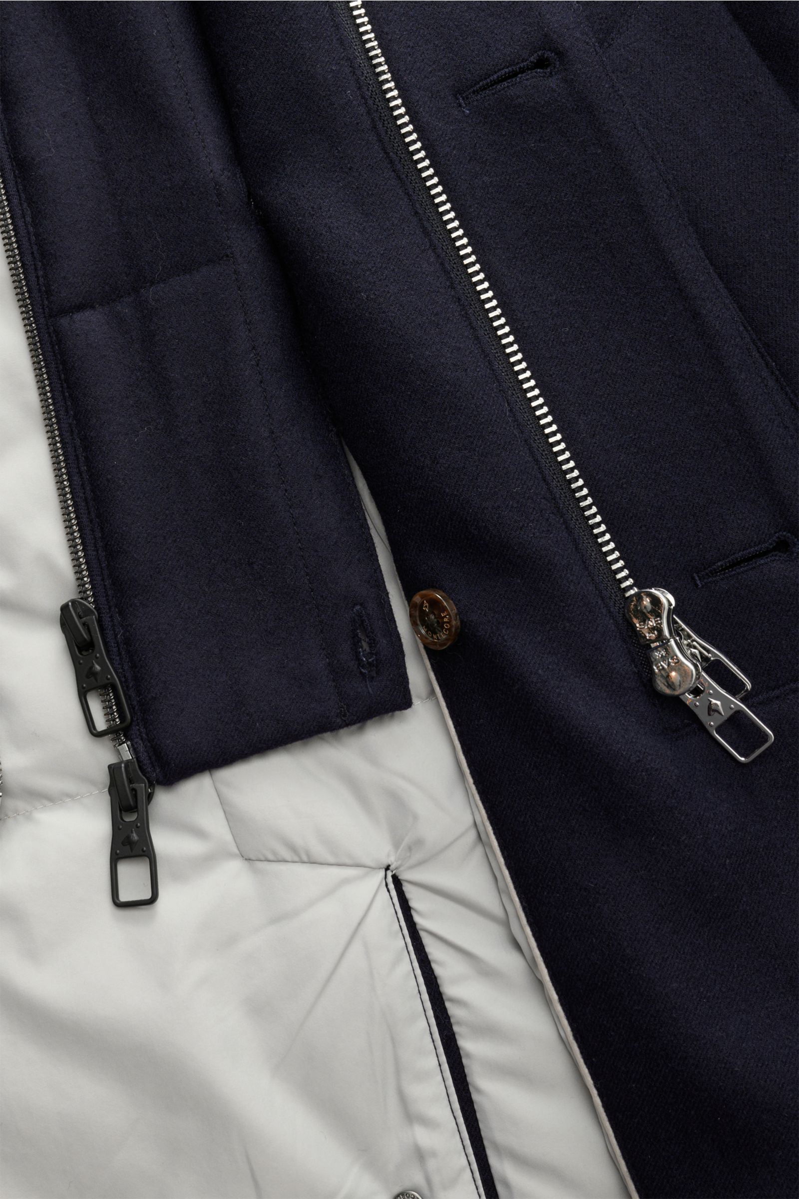 Close-up inside view of the Montecore Short down coat, navy, showing the lightweight quilted down lining, robust two-way zip, and storm flap with buttons.

An elegant essential for winter: This down jacket by MONTECORE is warm and comfortable, with an 