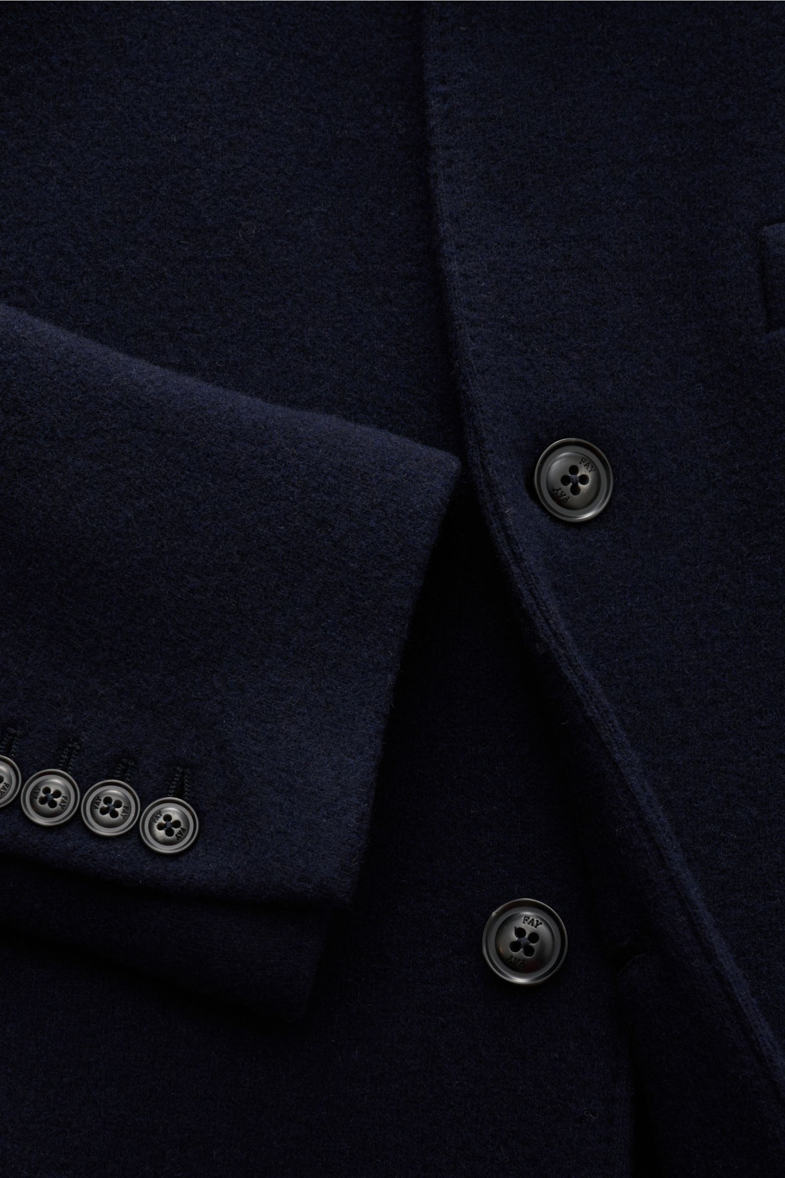 Close-up image from a front angle of the Fay Jersey-Mantel 'Duty Coat' navy, showing its melierte navy wool-microfiber jersey fabric, three-button front with branded buttons, soft texture, and cuff with five buttons. Flexibler Klassiker für Job und Alltag
