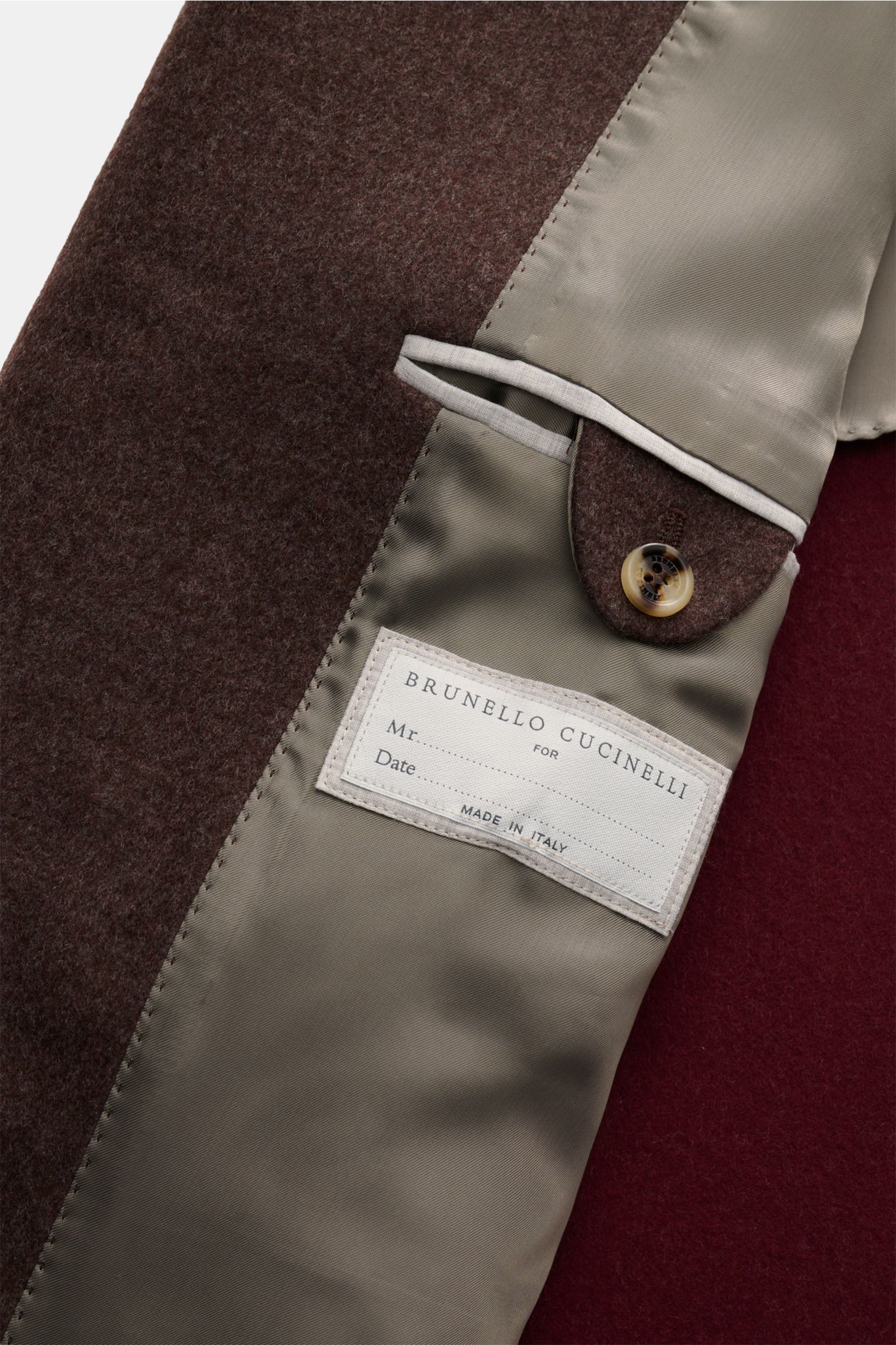 Close-up interior view of the Brunello Cucinelli Coat brown showing soft wool fabric, beige lining, label, and button detail. Look forward to the cold weather: The luxurious unconstructed coat by Italian label BRUNELLO CUCINELLI, made of soft wool and enh