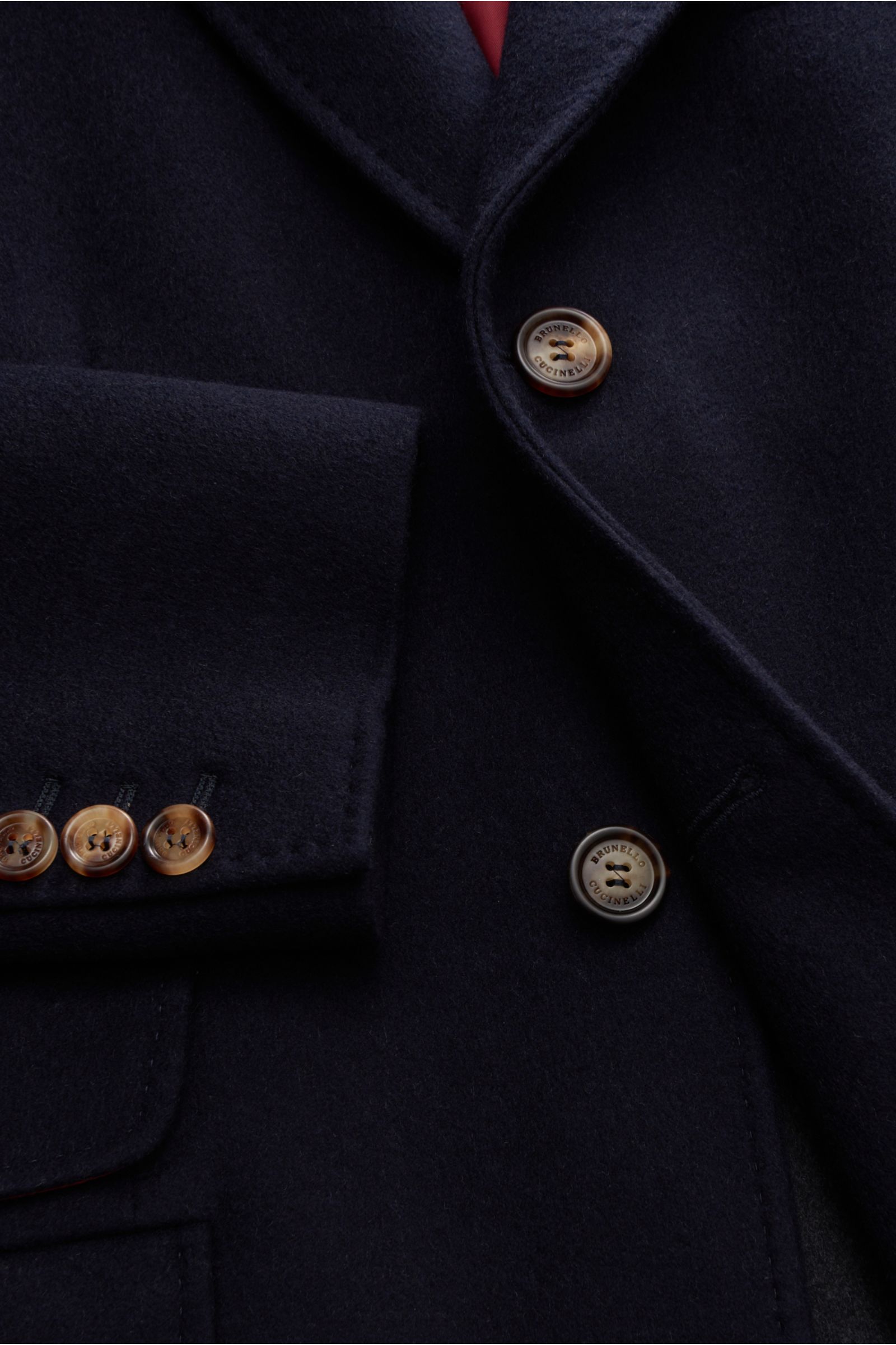Close-up front view of the Brunello Cucinelli Coat navy made of pure wool, showing soft texture, three-button placket, and cuff buttons. Look forward to the cold weather: The luxurious unconstructed coat by Italian label BRUNELLO CUCINELLI, made of sof