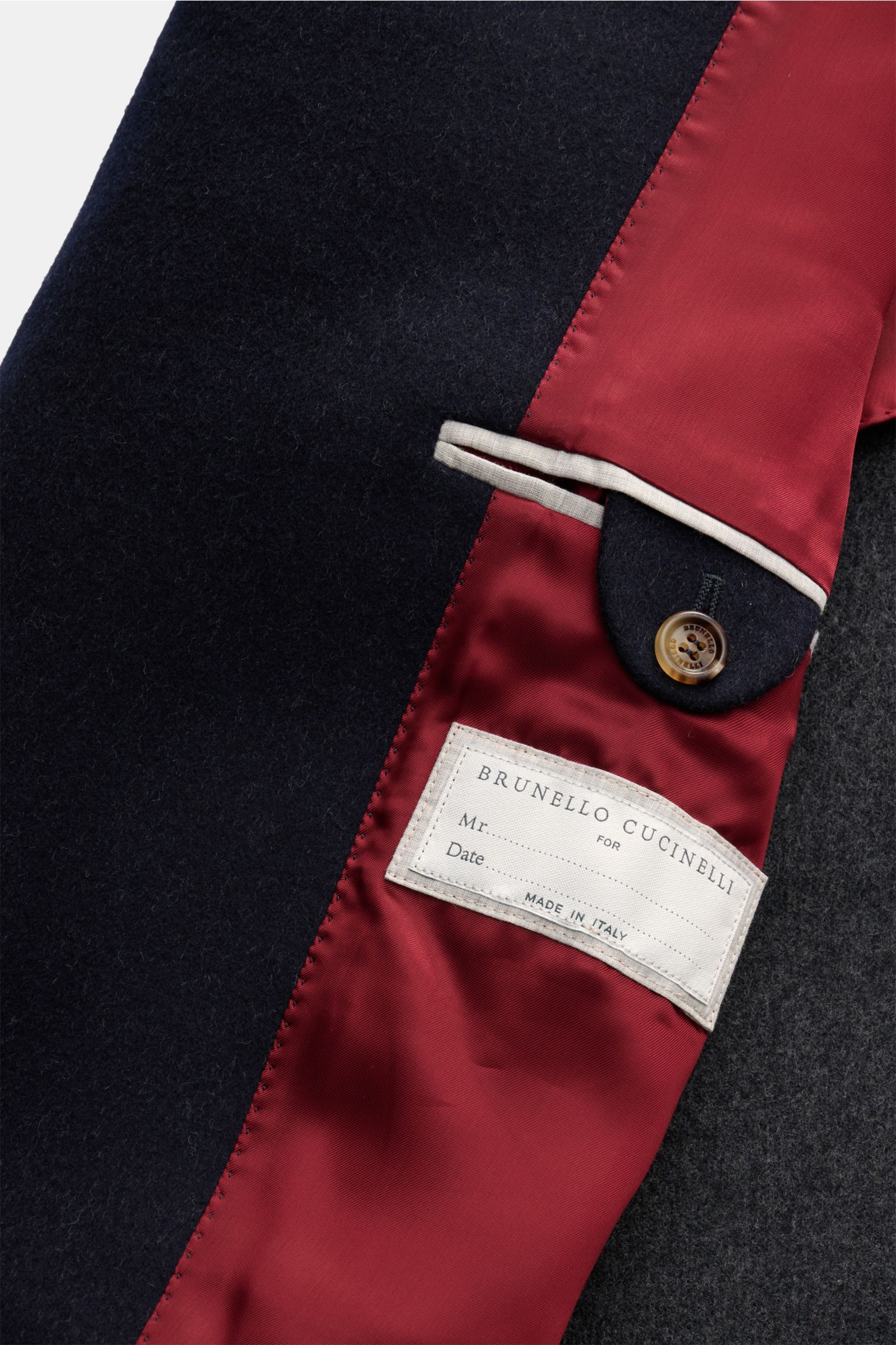 Nahaufnahme des halb gefütterten Brunello Cucinelli Wollmantel navy mit rotem Innenfutter, Innentasche und Knopf.