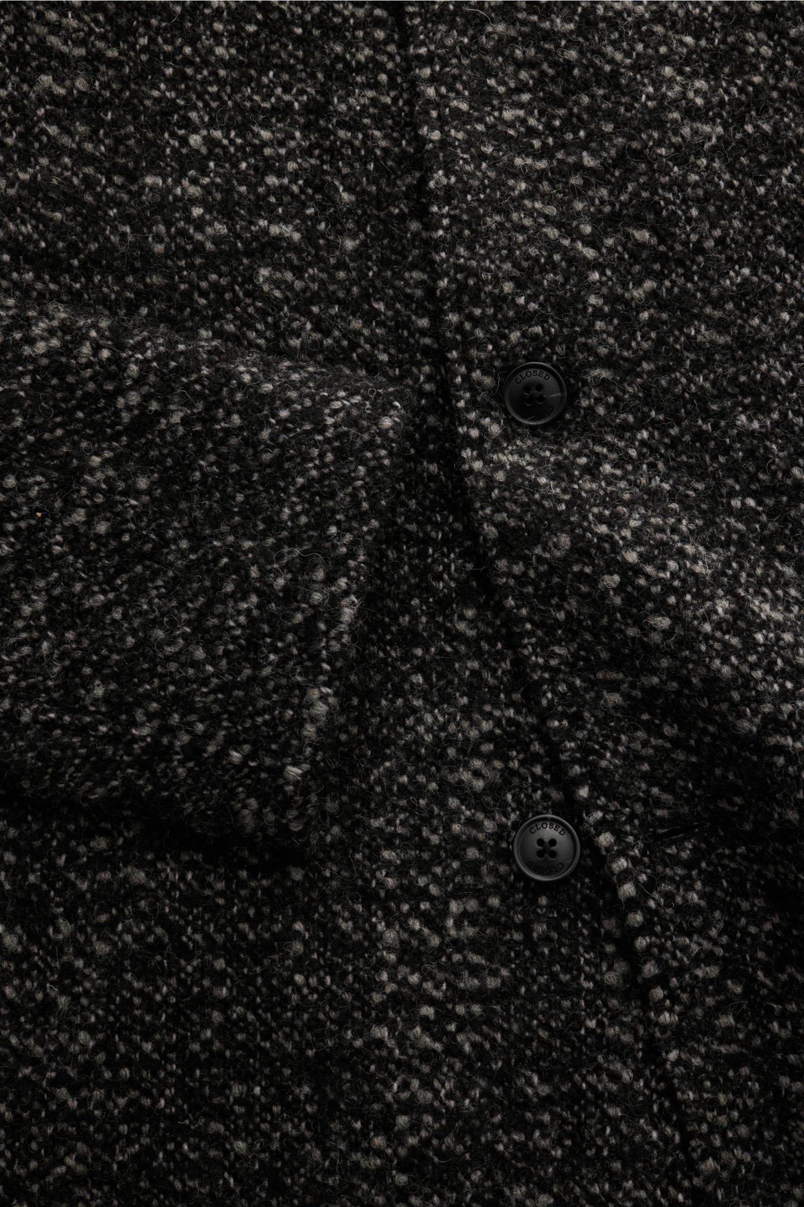 Close-up-Ansicht des Closed Mantels schwarz/grau in Salt and Pepper-Optik mit weichem Griff, Slim Fit, Umlegekragen, fünf Knöpfen, versteckten Hüfttaschen und Loop-Garn-Effekt.