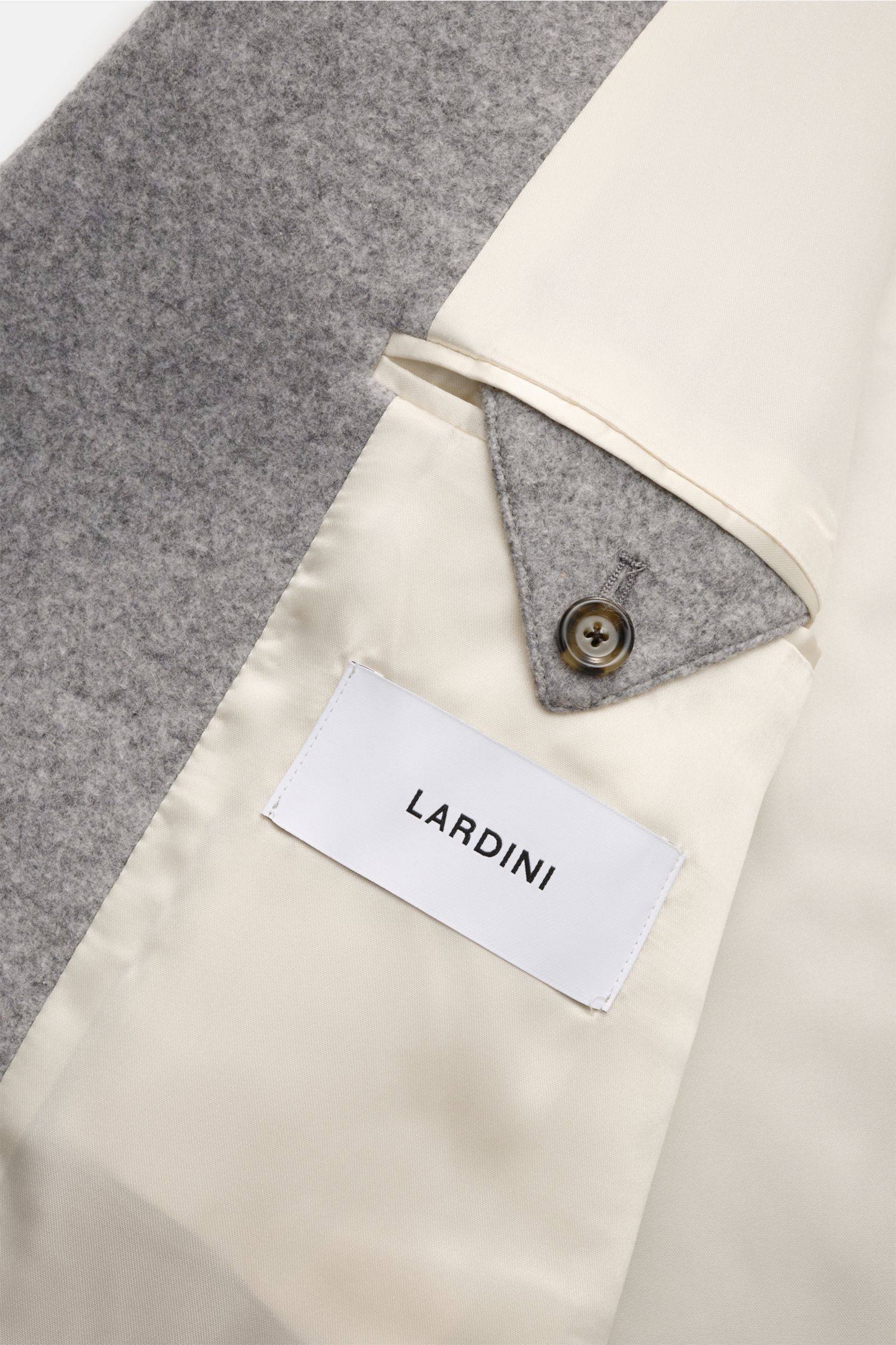 Close-up inside view of Lardini Mantel grau showing soft gray wool fabric, cream-colored lining, buttoned inner flap, and Lardini label.

Description included:  
Ein perfekter Mantel vereint zeitloses Design, eine klassische Silhouette und erlesene Mat