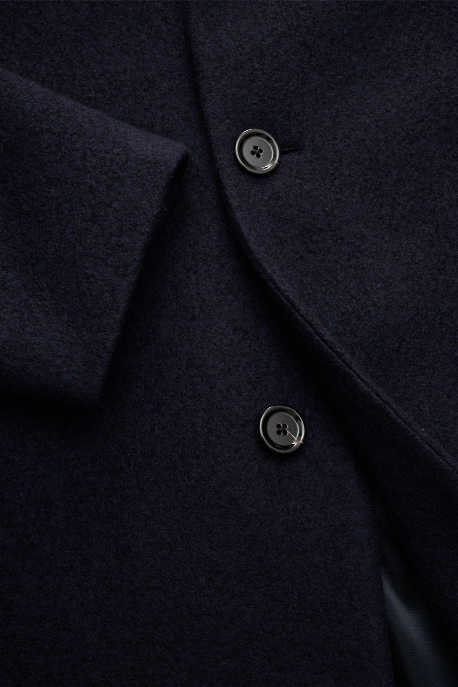 Close-up front view of Lardini Mantel navy wool coat with three buttons, soft texture, and classic lapel with flower pin.

Description: Ein perfekter Mantel vereint zeitloses Design, eine klassische Silhouette und erlesene Materialien wie Cashmere, Sei