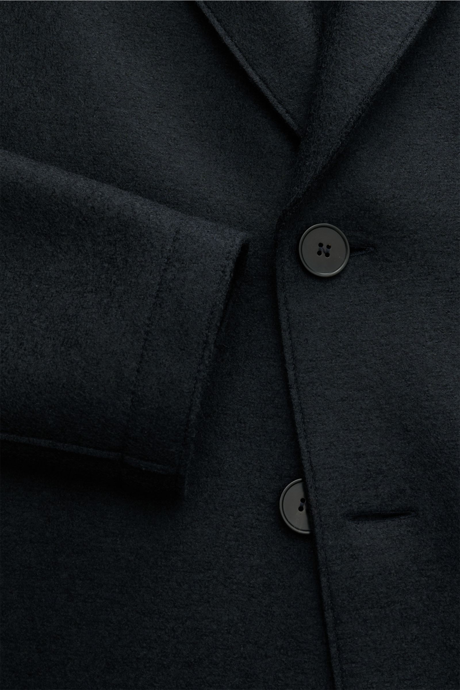 Close-up front view of Harris Wharf London Wollmantel navy, showing raw-edge finish, two black buttons, and heavy, pure felted wool texture. Zeitlos, pur und durchdacht: Dieser ungefütterte Mantel mit gerader Silhouette von HARRIS WHARF LONDON aus schw