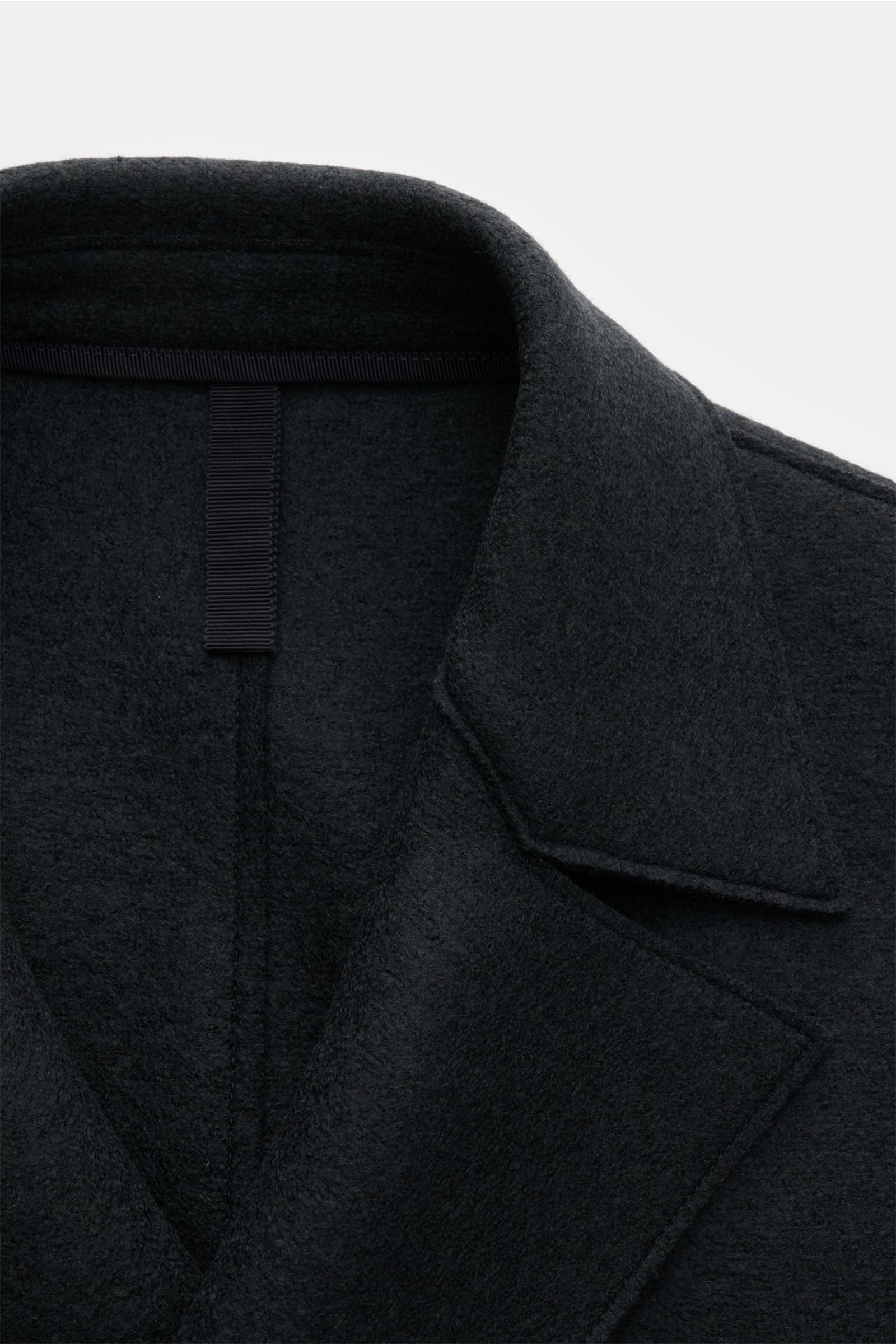 Close-up front view of the Harris Wharf London Wollmantel dunkelbraun showing the lapel and collar in dark brown felted pure wool with a raw-edge finish, regular fit, three-button placket, and unlined design. 

Zeitlos, pur und durchdacht: Dieser ungef