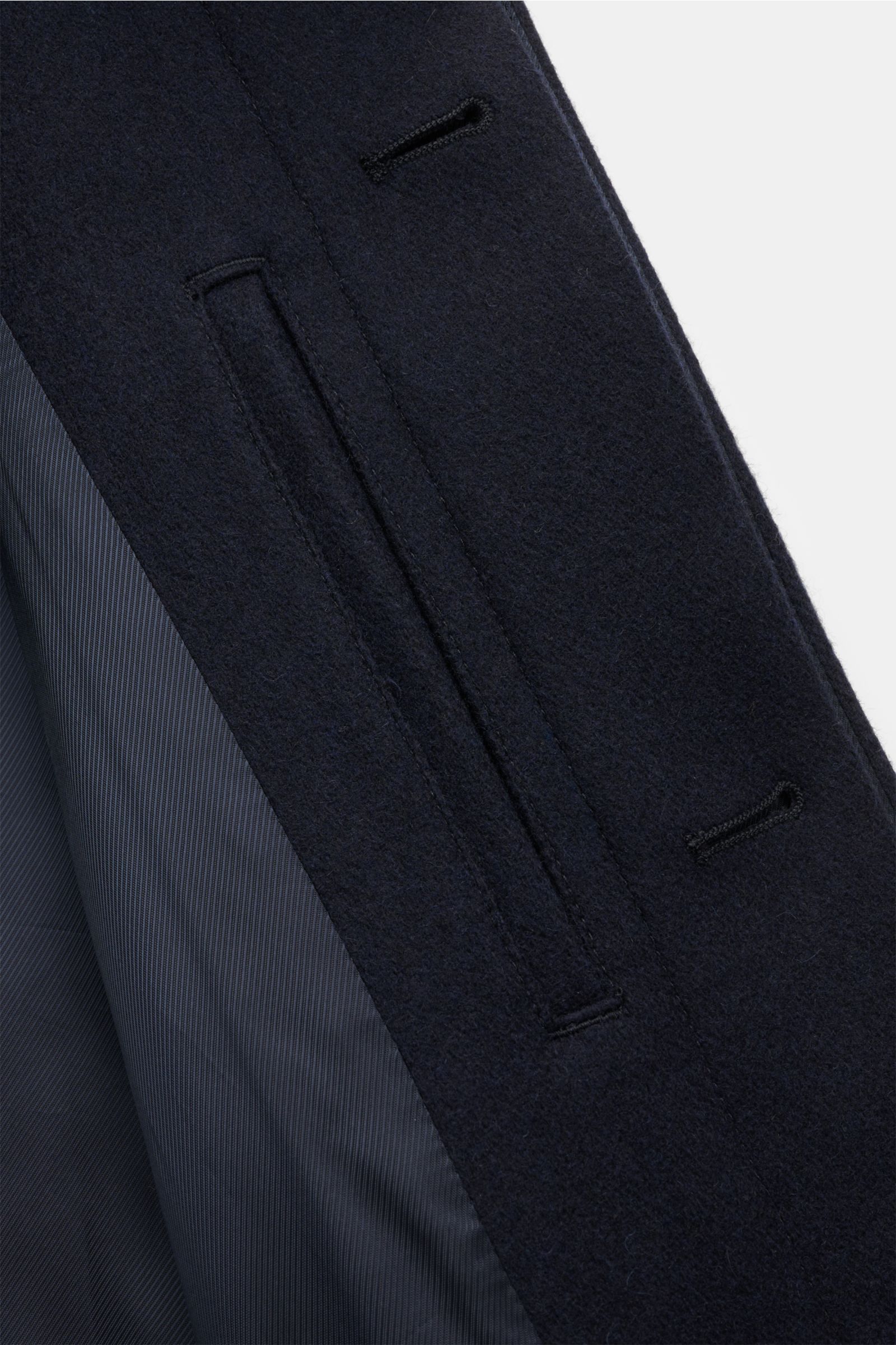 Close-up front-side view of the A.P.C. Mantel 'Mac Auster' navy, a stately coat with a straight silhouette made from felted wool and microfiber. It features a concealed five-button placket, large welt pockets, a turn-down collar, raglan sleeves, a central