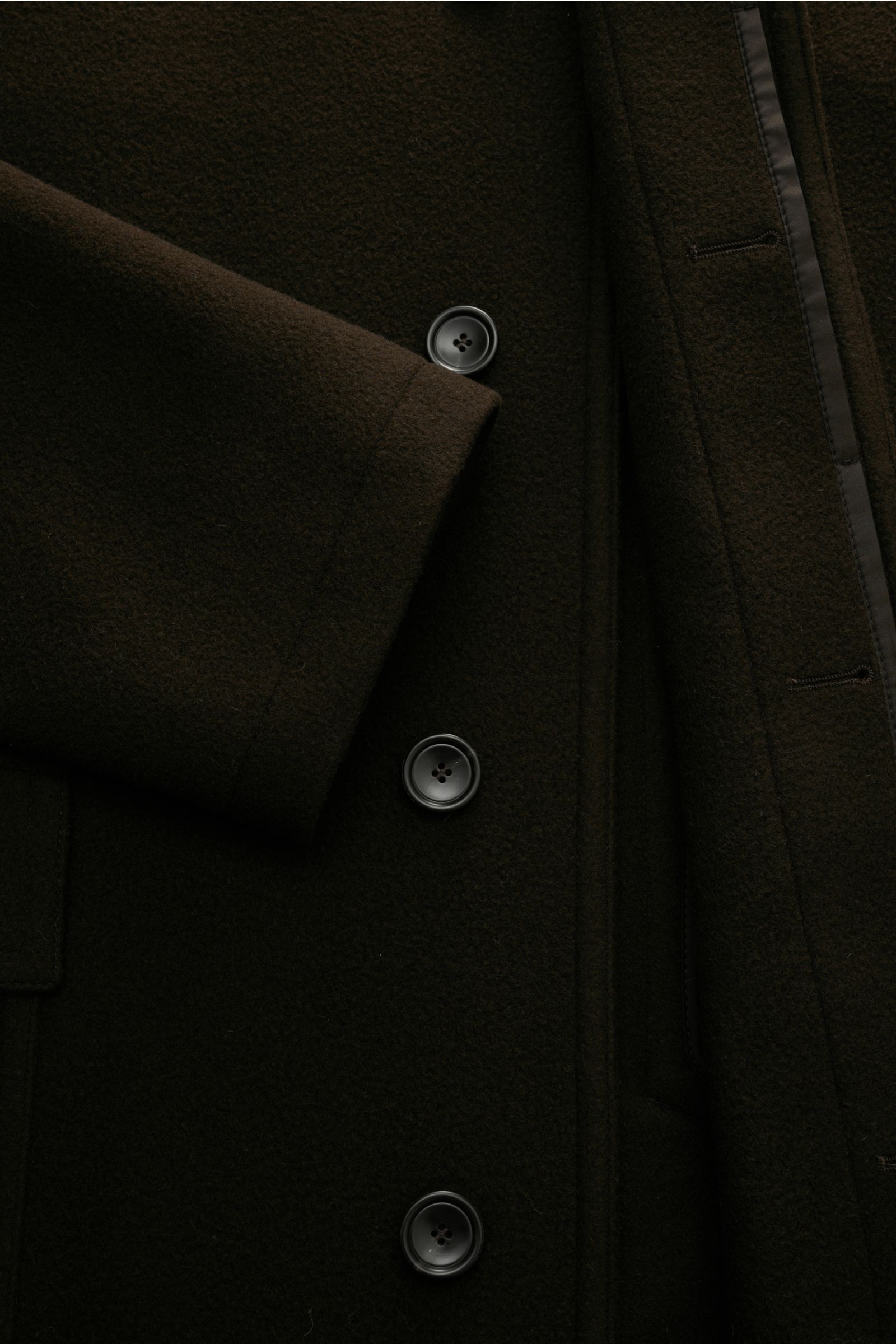 Close-up front view of the Tagliatore Coat 'Lloyd' dark brown showing pure virgin wool texture, concealed button placket, and sleeve cuff. Stylish classic: This elegant coat in pure virgin wool by TAGLIATORE can be styled in a range of timeless winter loo