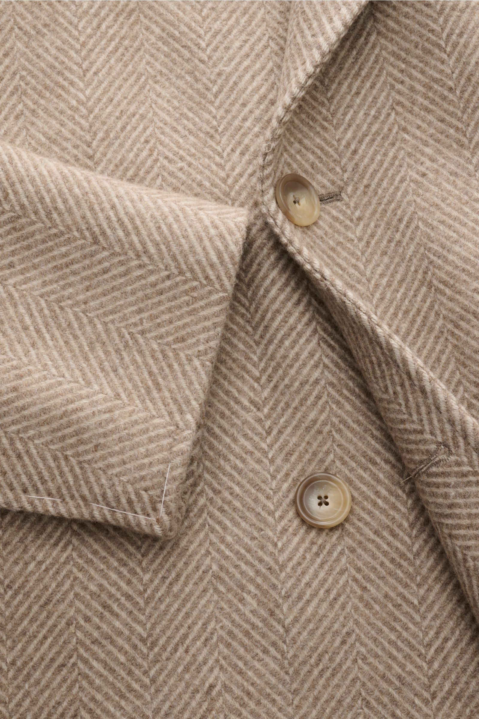Tagliatore Wollmantel beige/creme gemustert, Nahaufnahme von vorne, Fischgratmuster, Slim Fit, zweireihiger Drei-Knopf-Stil, weicher Griff aus Schurwolle und Cashmere.