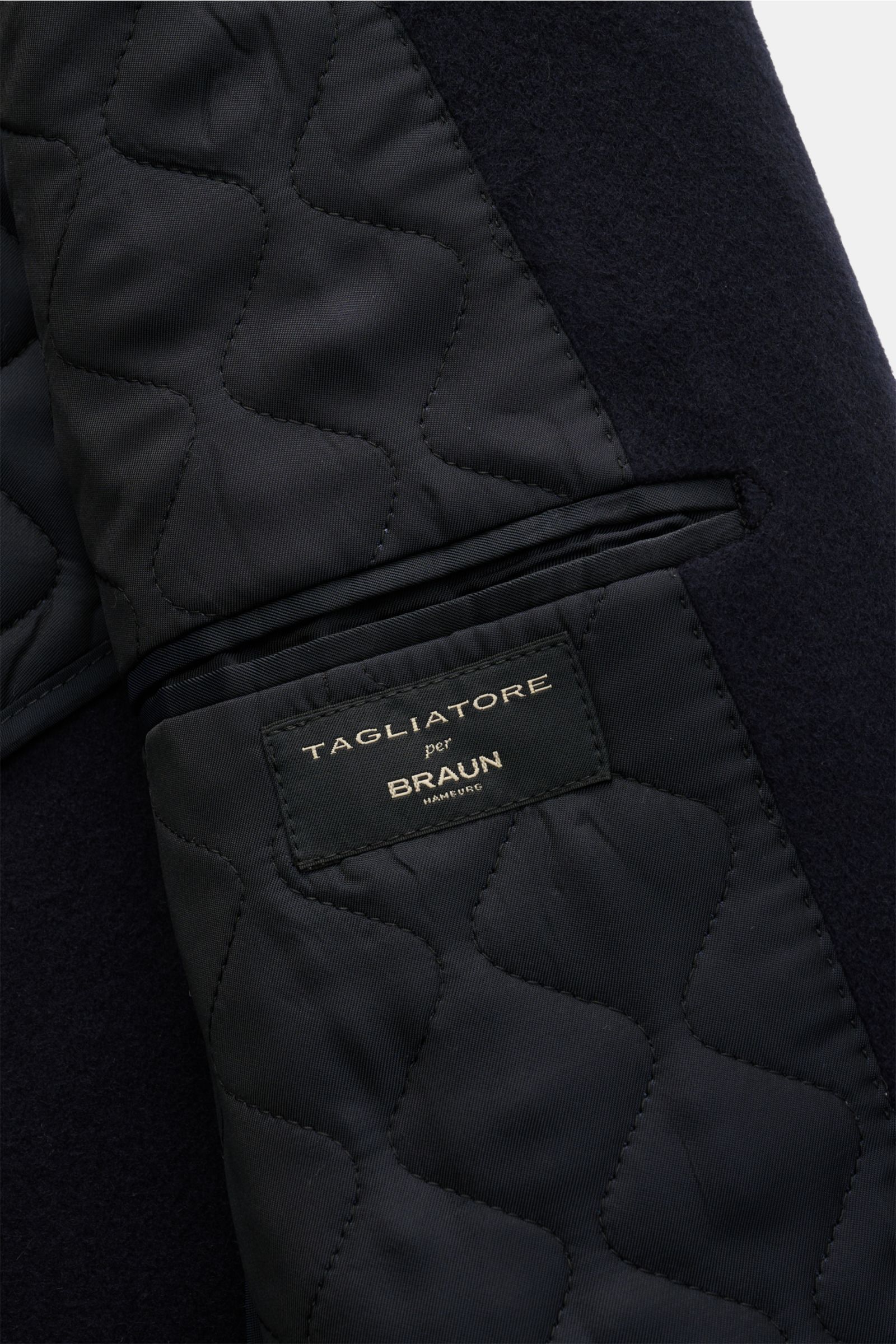 Close-up view of the inside pocket and label of the Tagliatore Cashmere Mantel navy, showcasing quilted lining and pure cashmere fabric. Luxus, der allein seinem Träger vorbehalten ist und keine Bühne braucht: TAGLIATORE präsentiert einen unkonsturierten 