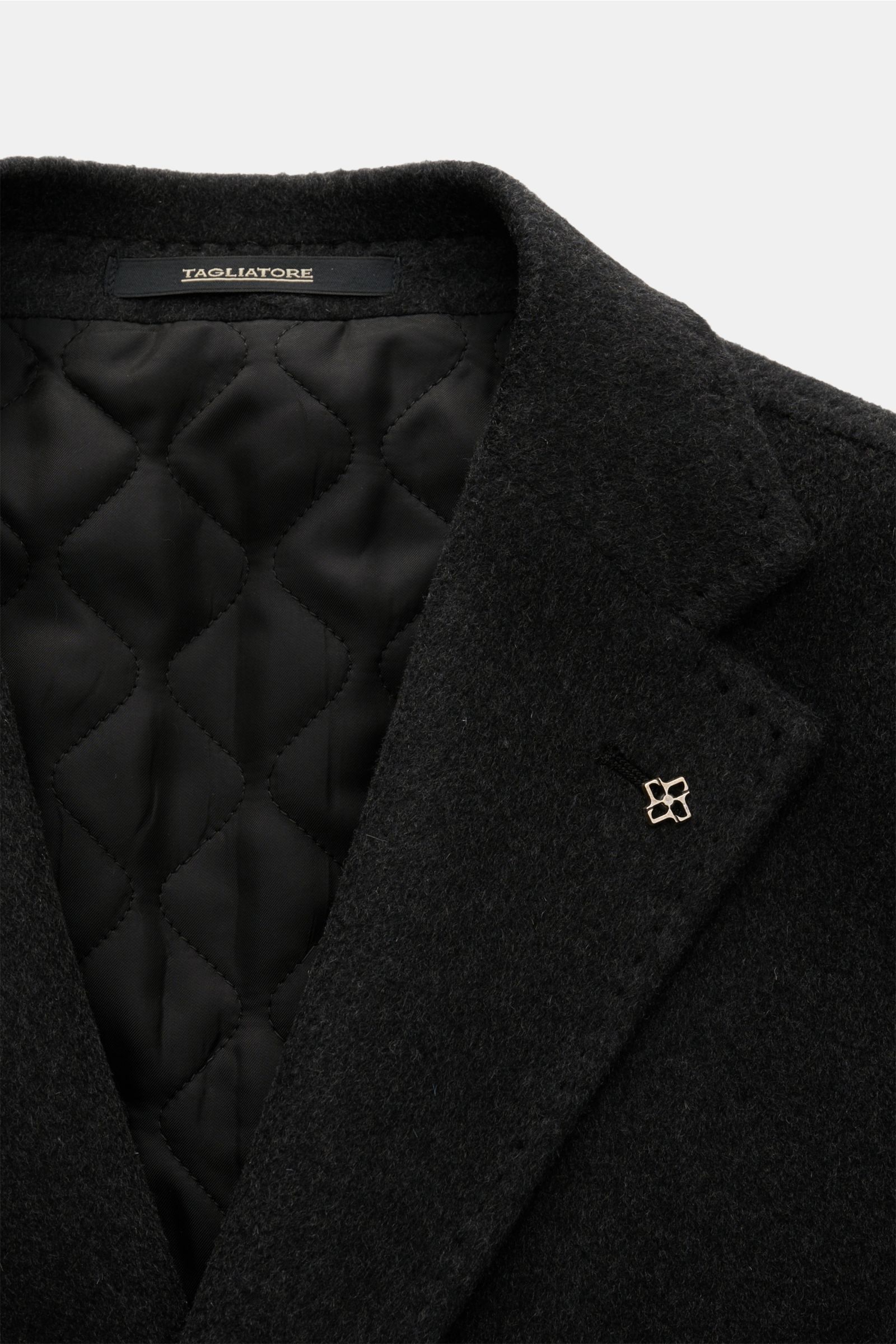 Close-up image of the top front of the Tagliatore Cashmere Mantel anthrazit, showing the lapel with a pin and quilted black inner lining. Luxus, der allein seinem Träger vorbehalten ist und keine Bühne braucht: TAGLIATORE präsentiert einen unkonsturierten