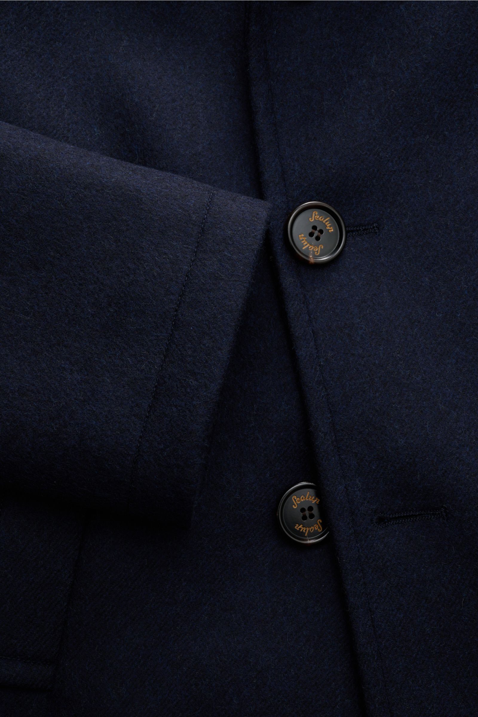 Close-up front detail of Sealup Caban-Kurzmantel dark navy, showing soft pure wool fabric, slim fit, two buttons, and clean stitching from a top-down angle. This short peacoat from Sealup features pure wool, soft touch, light padding, slim fit, double-bre