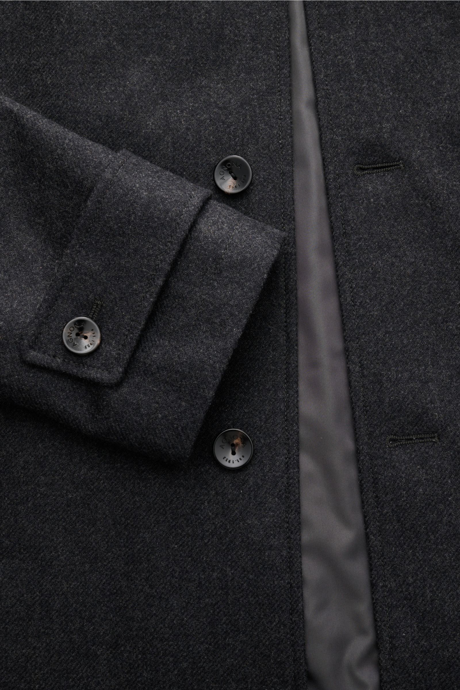 Close-up front view of the Agnona Cashmere Mantel anthrazit showing dark grey wool fabric, buttons with 'Agnona' engraving, and a smooth inner lining.