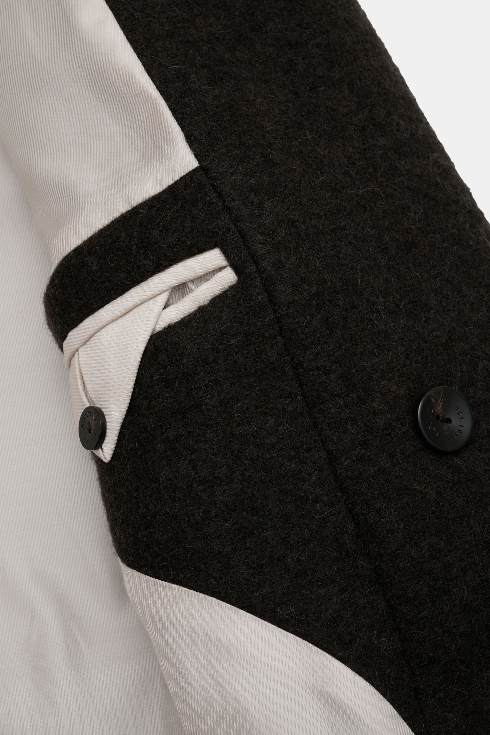 Close-up interior view of the Agnona Cashmere Mantel anthrazit, showing the soft twill lining, buttoned sleeve cuff, and wool fabric texture. The clean cashmere coat features five-button front, regular fit, and diagonal welt pockets. Der cleane Cashmer