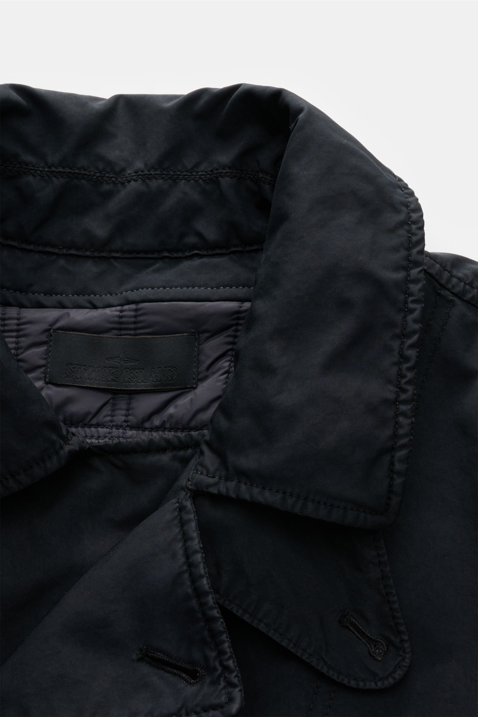 Stone Island Jacke 'David-TC Ghost Piece' navy shown in close-up from above, highlighting the collar and stitching, made of robust cotton with Anti-Drop-Finish, soft touch, slim fit, overlapping button placket, variable collar with button strap, angled we