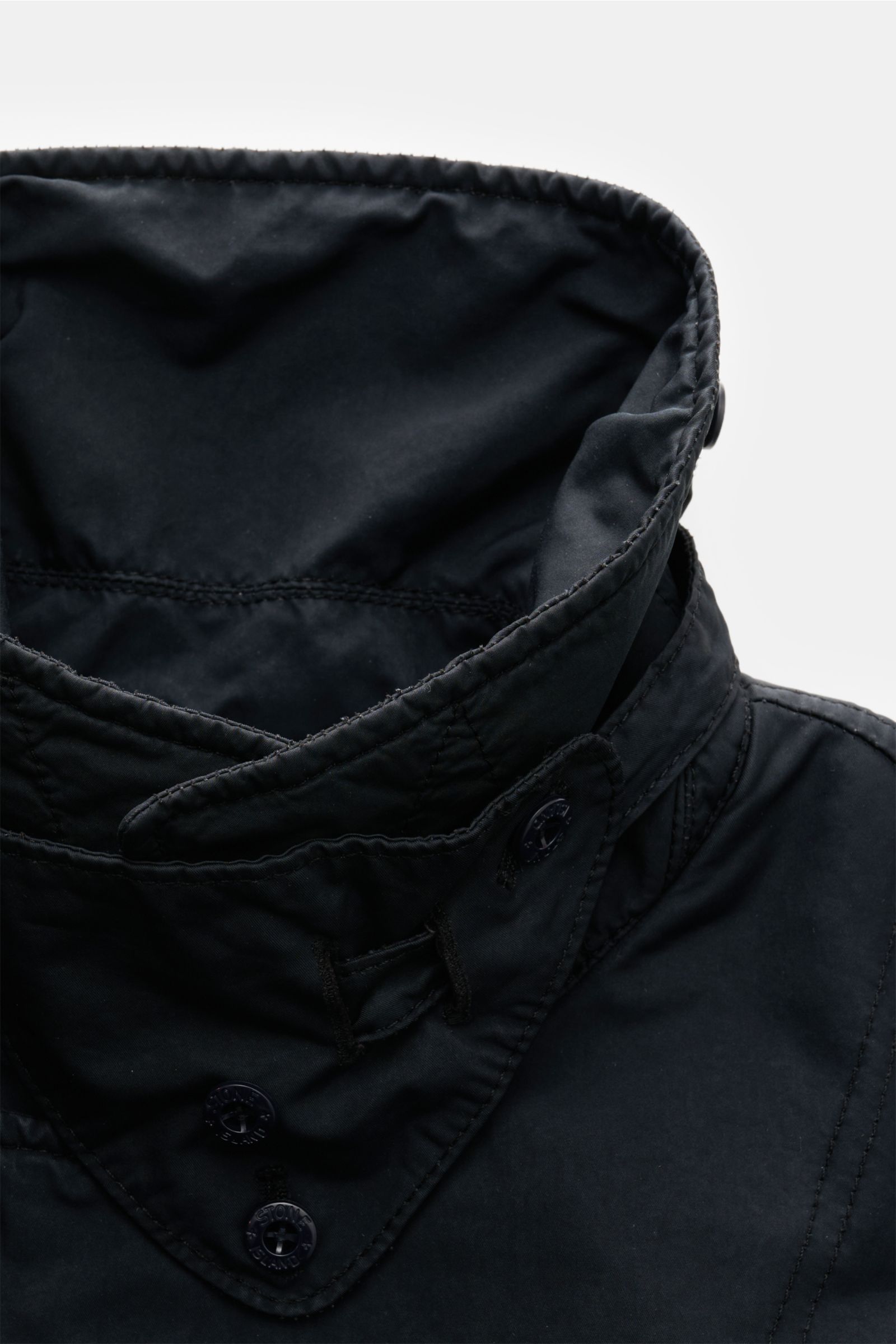 Close-up front view of the collar and upper chest of the Stone Island Jacke 'David-TC Ghost Piece' navy, showing its slim fit, soft anti-drop fabric, and tonal buttons. Bestens gewappnet für die Übergangszeit: Die leicht gefütterte Jacke 'David-TC' von ST