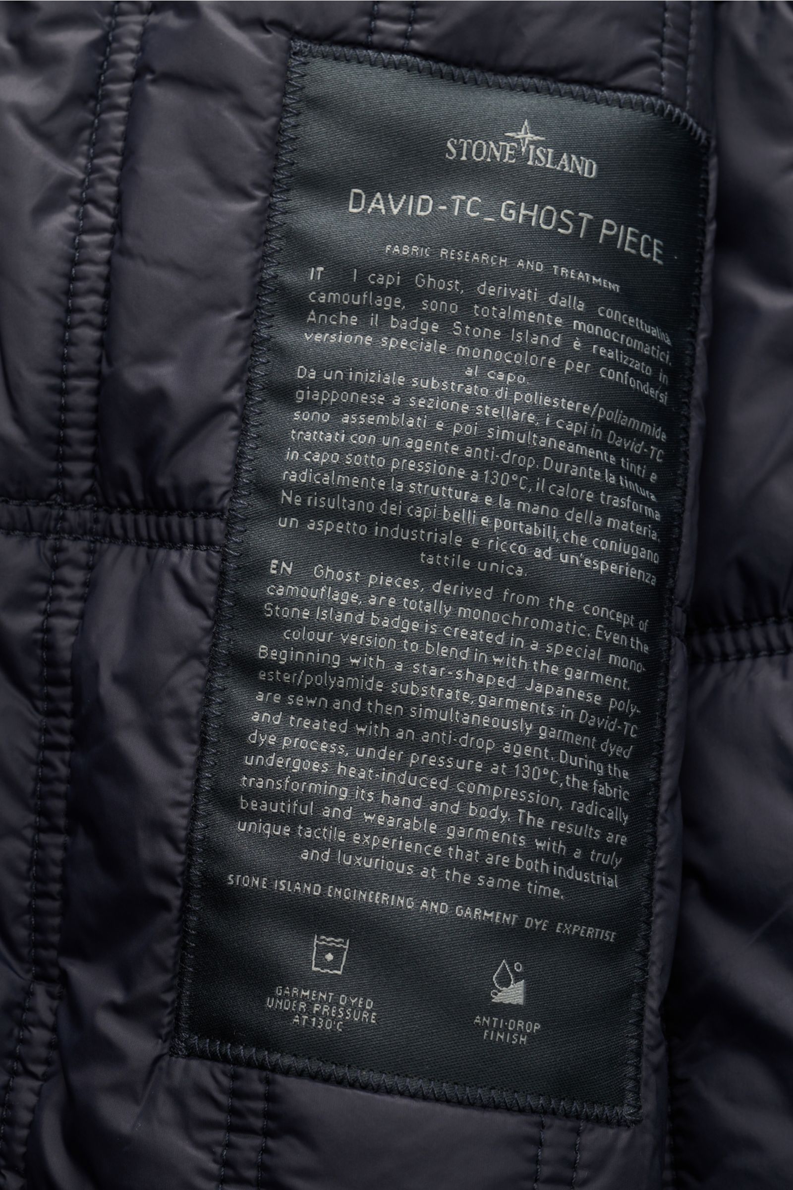 Close-up interior label view of Stone Island Jacke 'David-TC Ghost Piece' navy, showing fabric research details and care icons, highlighting its anti-drop finish and garment dye process. Bestens gewappnet für die Übergangszeit: Die leicht gefütterte Jacke