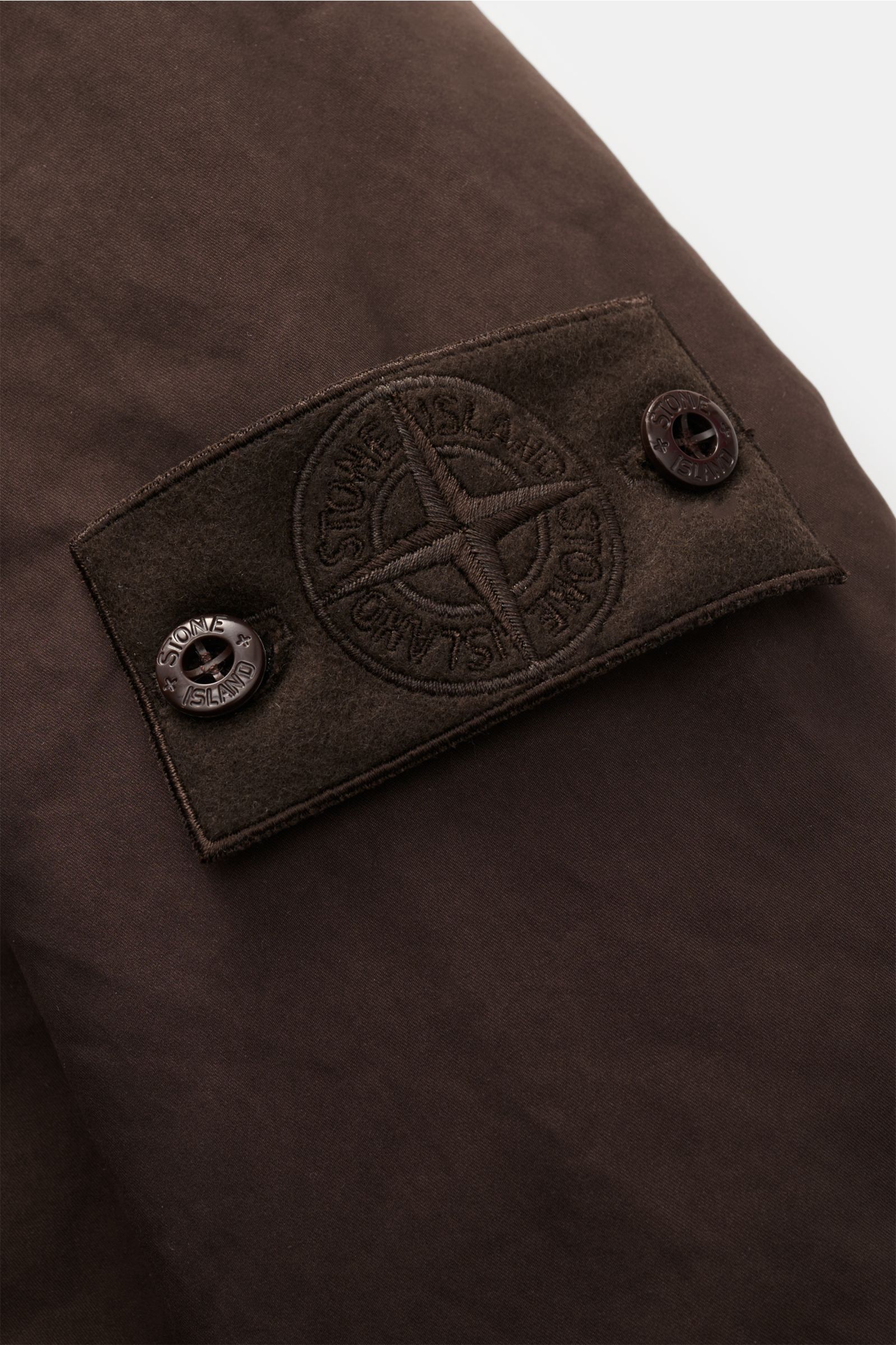 Stone Island Jacke 'David-TC Ghost Piece' dunkelbraun, Detailansicht Badge am Ärmel aus robuster Baumwolle mit Anti-Drop-Finish
