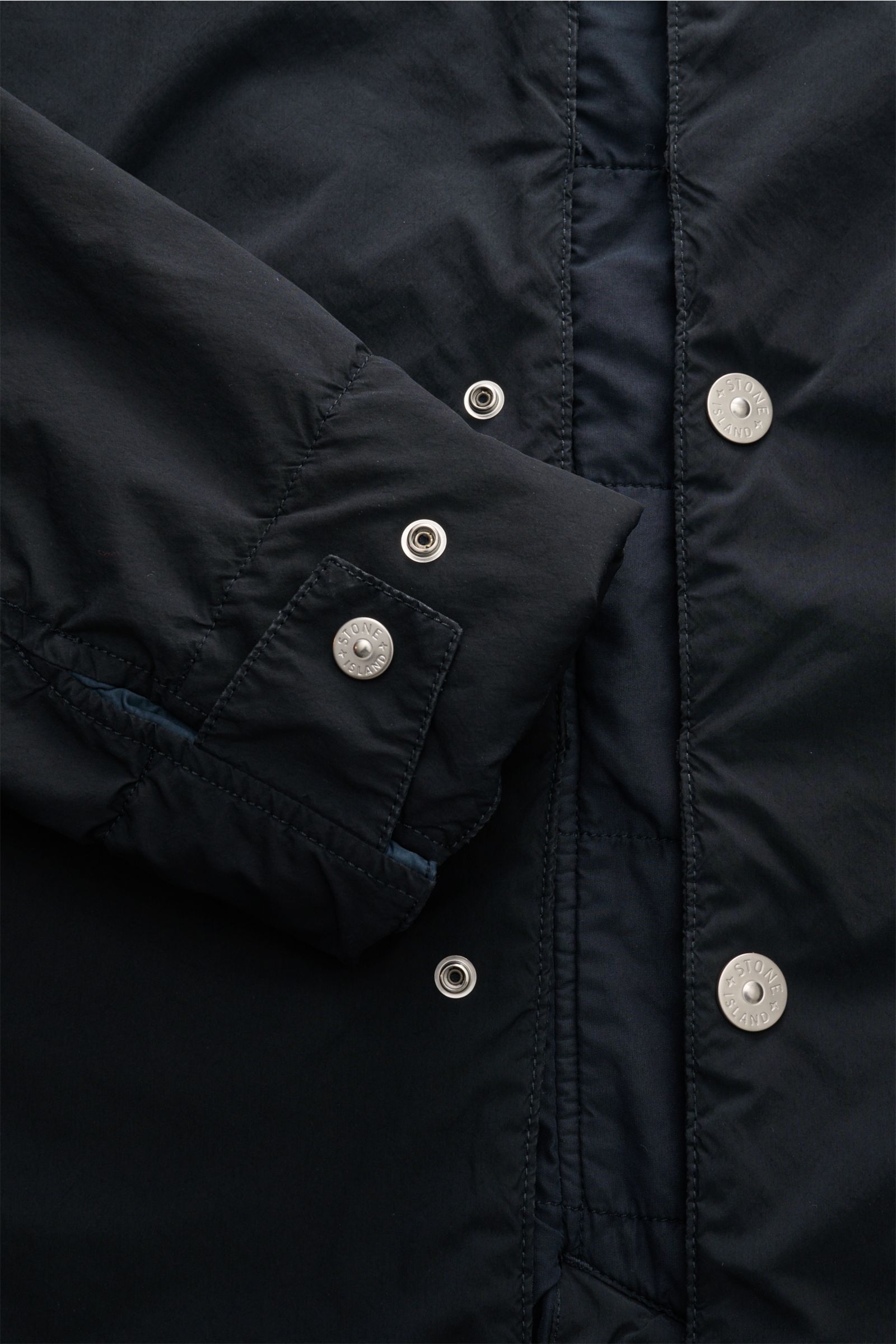 Stone Island Parka 'Light Compact Touch Poly-TC' dark navy, Detailaufnahme der Knopfleiste und Manschette mit Kompass-Badge, Slim Fit, wind- und wasserabweisend, leichte Wattierung.