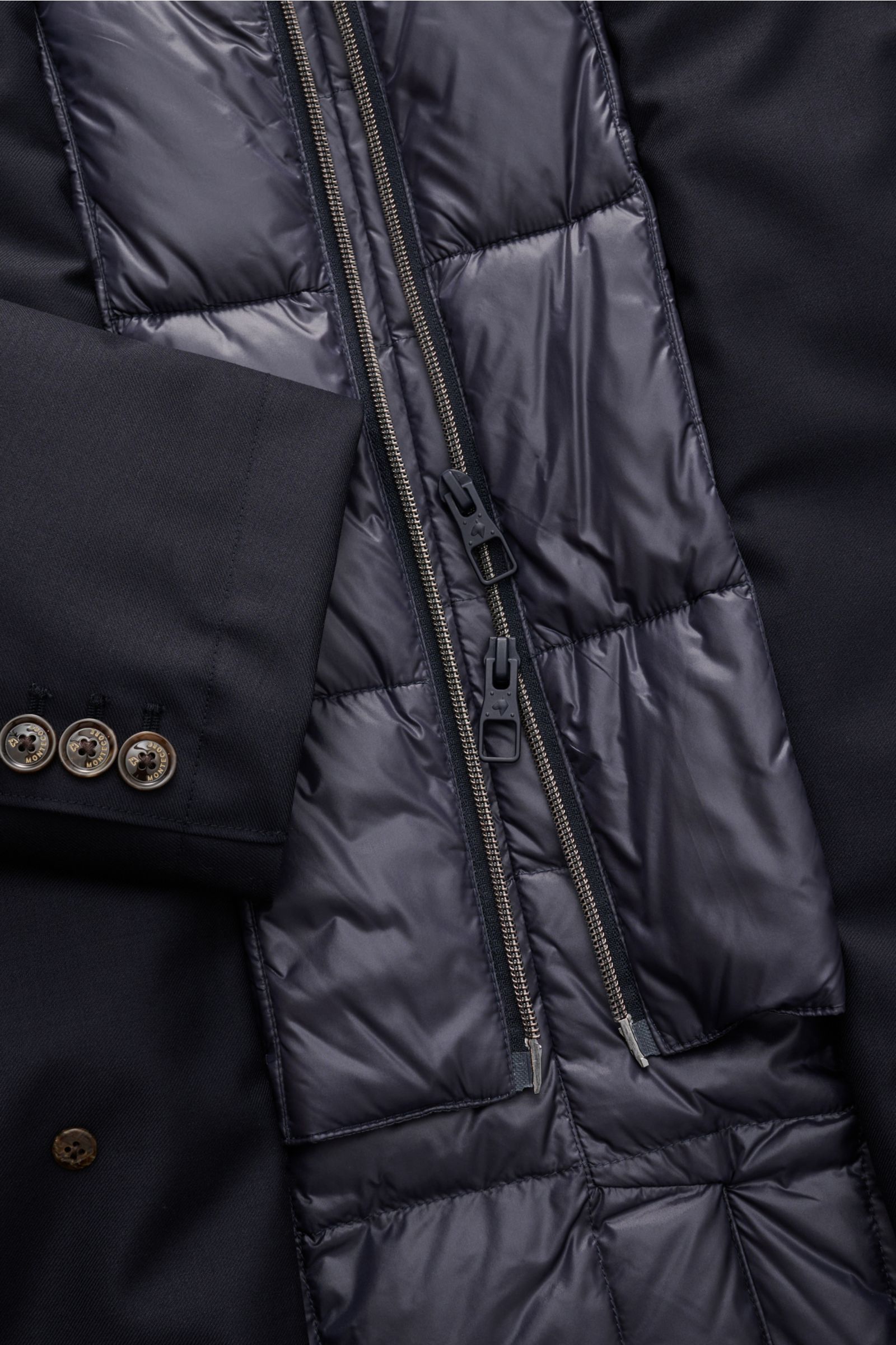 Close-up inside view of the Montecore Daunen-Kurzmantel navy showing quilted, warm down filling with double zipper and sleeve buttons. -

Twill aus reiner Super 120'S Schurwolle
leicht griffige Qualität
wind- und wasserabw