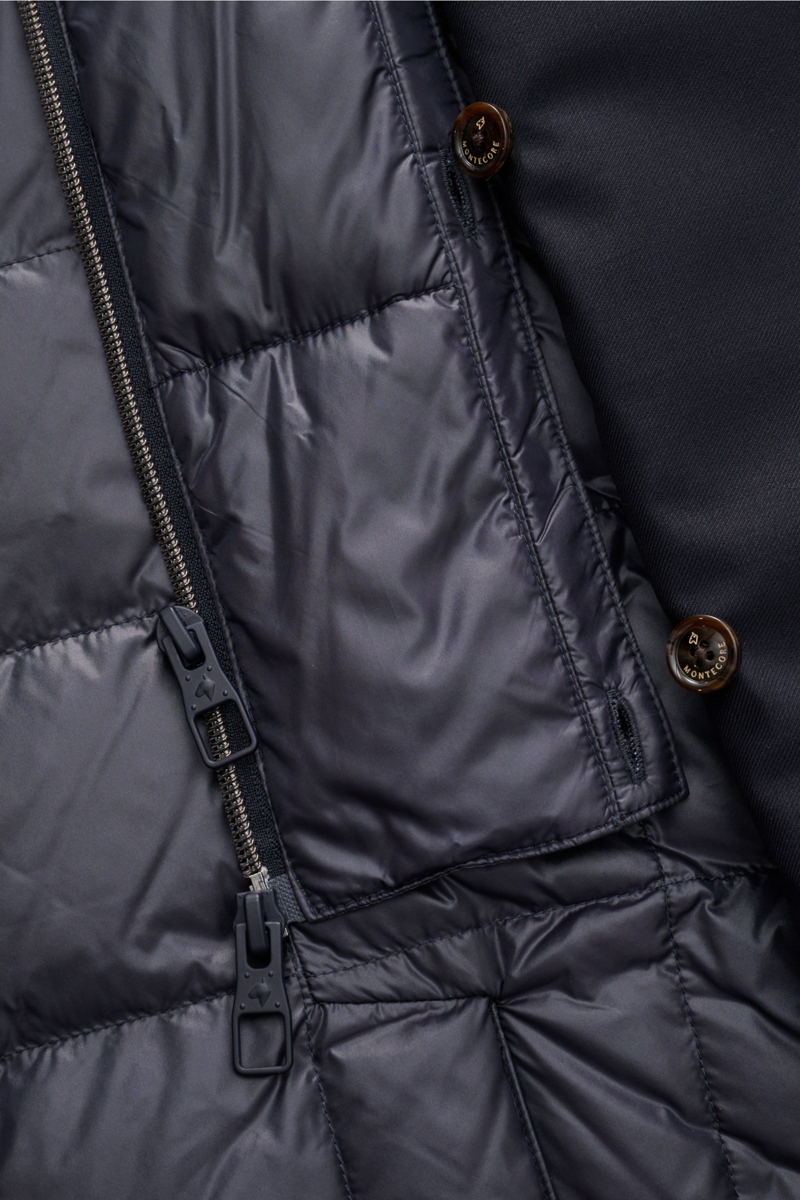 Close-up view of the interior and zipper details of the Montecore Daunen-Kurzmantel navy with leather buttons and quilted lining.

-

Twill aus reiner Super 120'S Schurwolle
leicht griffige Qualität
wind- und wasserabweise