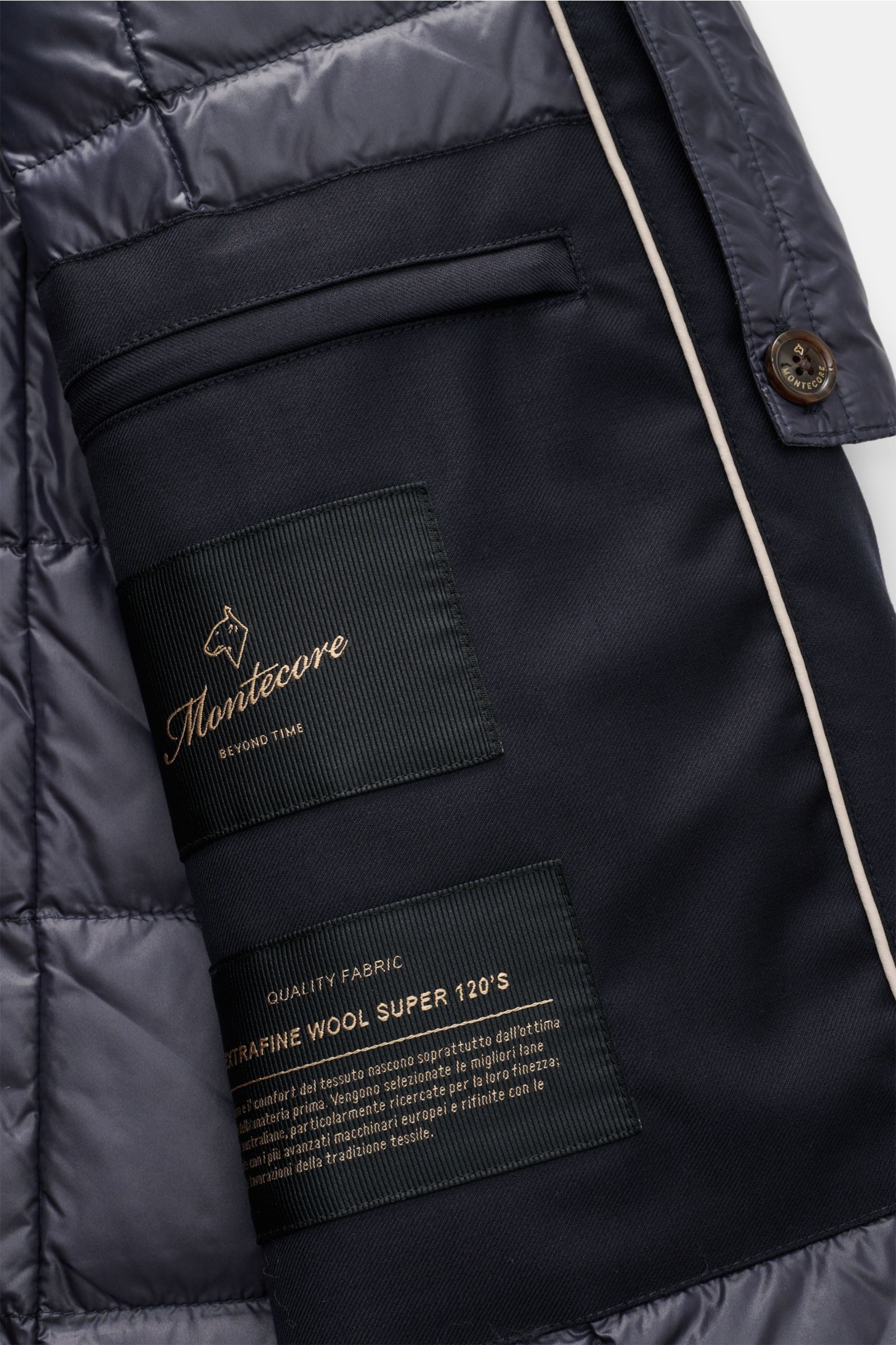 Close-up interior view of the Montecore Daunen-Kurzmantel navy showing quilted lining, fabric labels, and button detail. -

Twill aus reiner Super 120'S Schurwolle
leicht griffige Qualität
wind- und wasserabweisend
