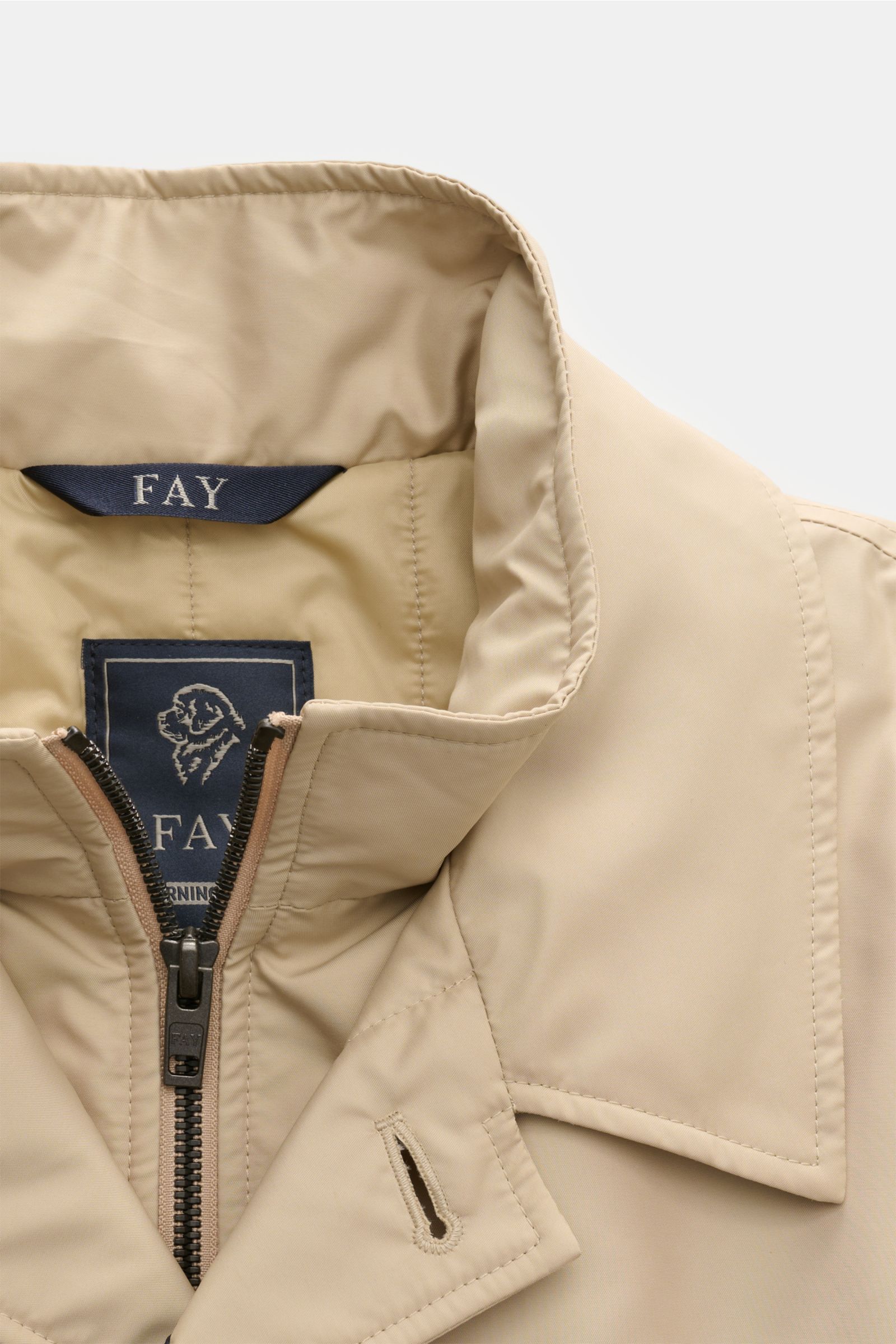 Close-up front view of the Fay Mantel 'Morning Coat' beige showing the collar, robust zipper, and smooth technical microfiber poplin fabric with light padding.

 

Popeline aus technischer Microfaser
glatter Griff
wasserab