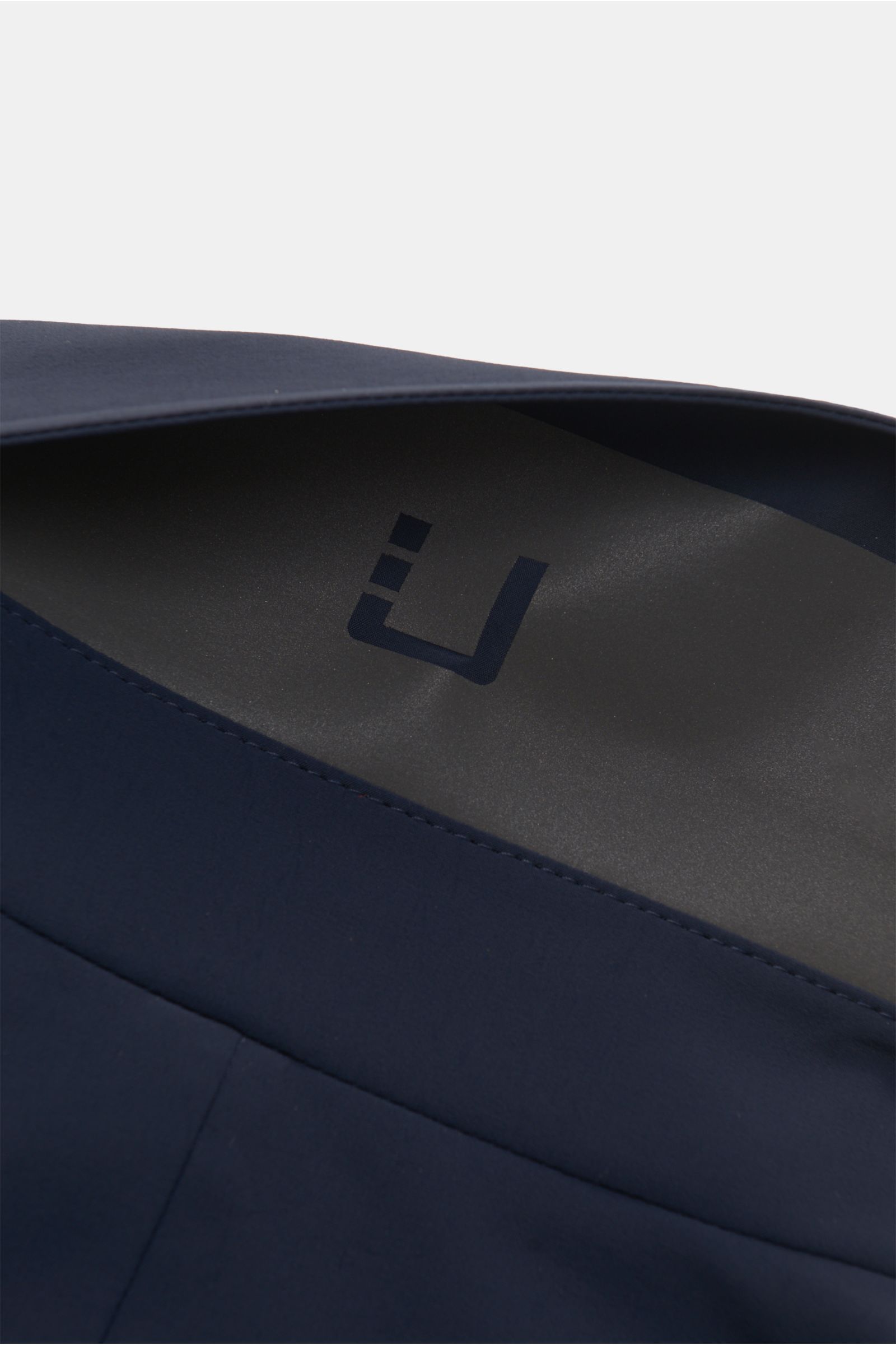 Close-up detail of the inside collar of the UBR Kurzmantel 'Regulator Coat' navy, showing smooth microfiber fabric and subtle branding, photographed from an angled top-down perspective. Leicht und besonders funktional ist das Modell 'Regulator Coat' des n