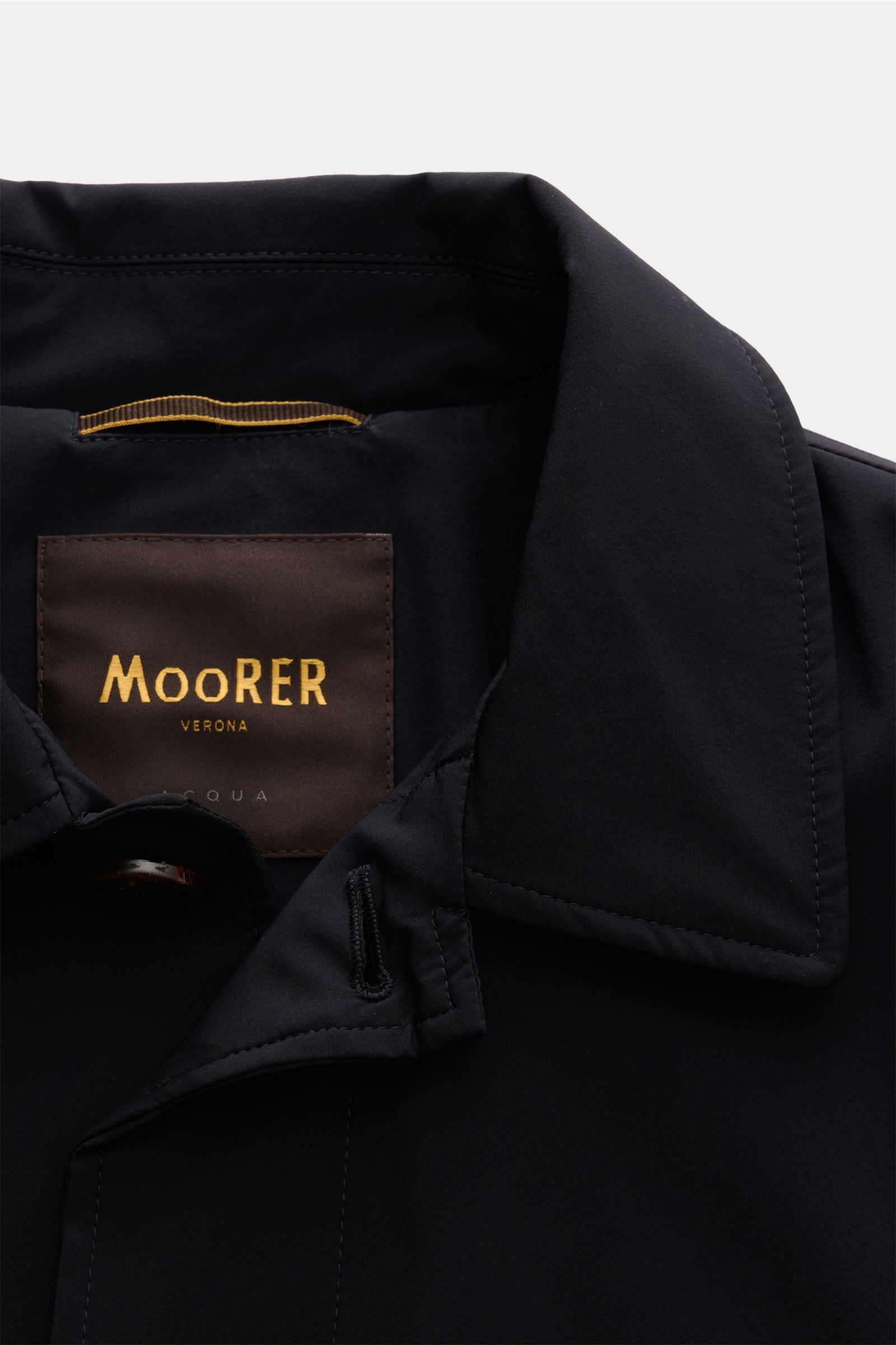 Close-up front view of the Moorer Kurzmantel 'Vittor' dark navy collar and label, showcasing lightweight, water-repellent microfiber with smooth grip and Italian craftsmanship. Souveräne Eleganz für jeden Tag: Der leichte Mantel 'Vittor' überzeugt mit sei