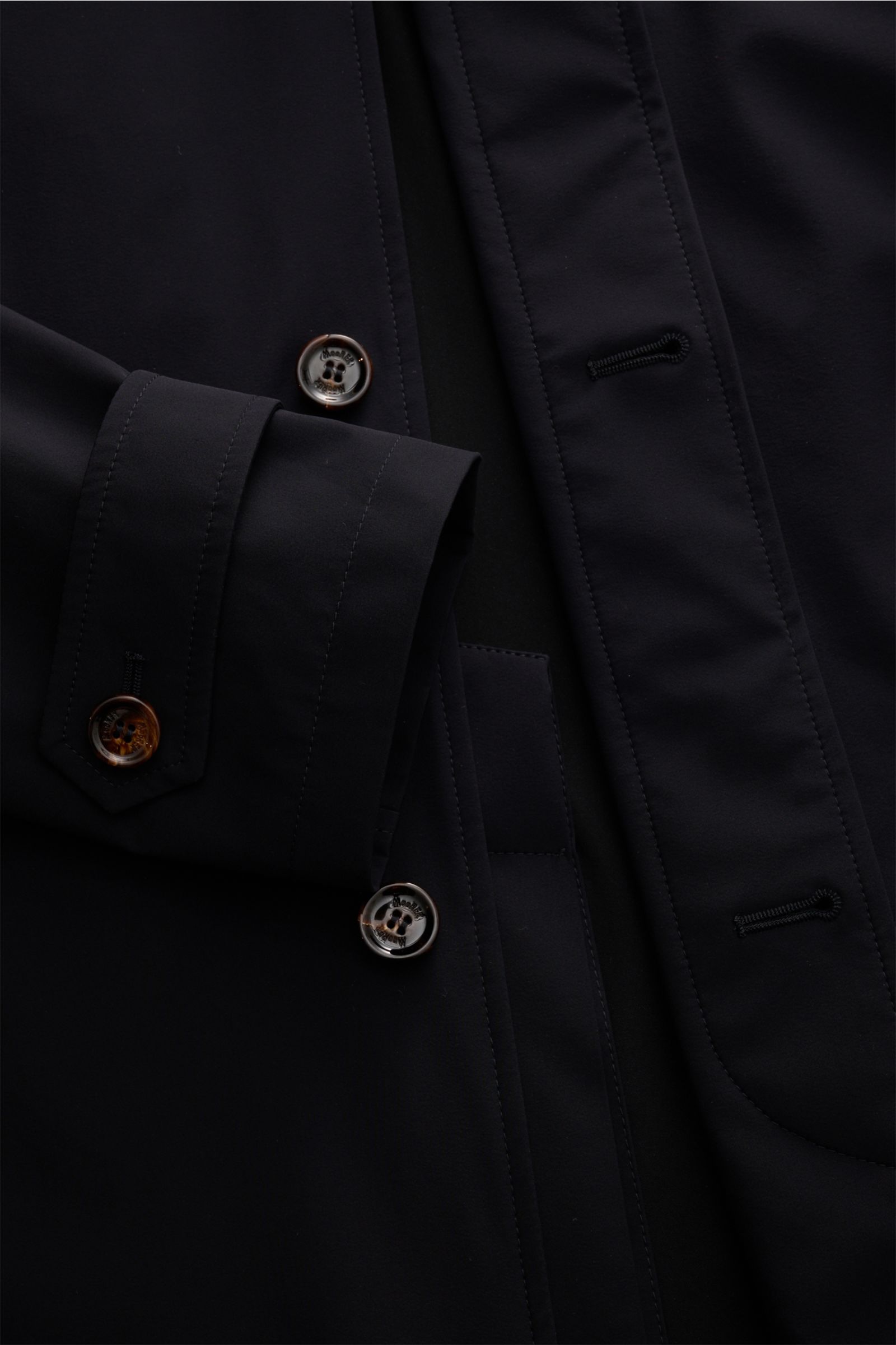 Close-up front view of Moorer Kurzmantel 'Vittor' dark navy, showing water-repellent microfiber, slim fit, button details, and cuff with button strap.

Souveräne Eleganz für jeden Tag: Der leichte Mantel 'Vittor' überzeugt mit seiner hochwertigen, wass
