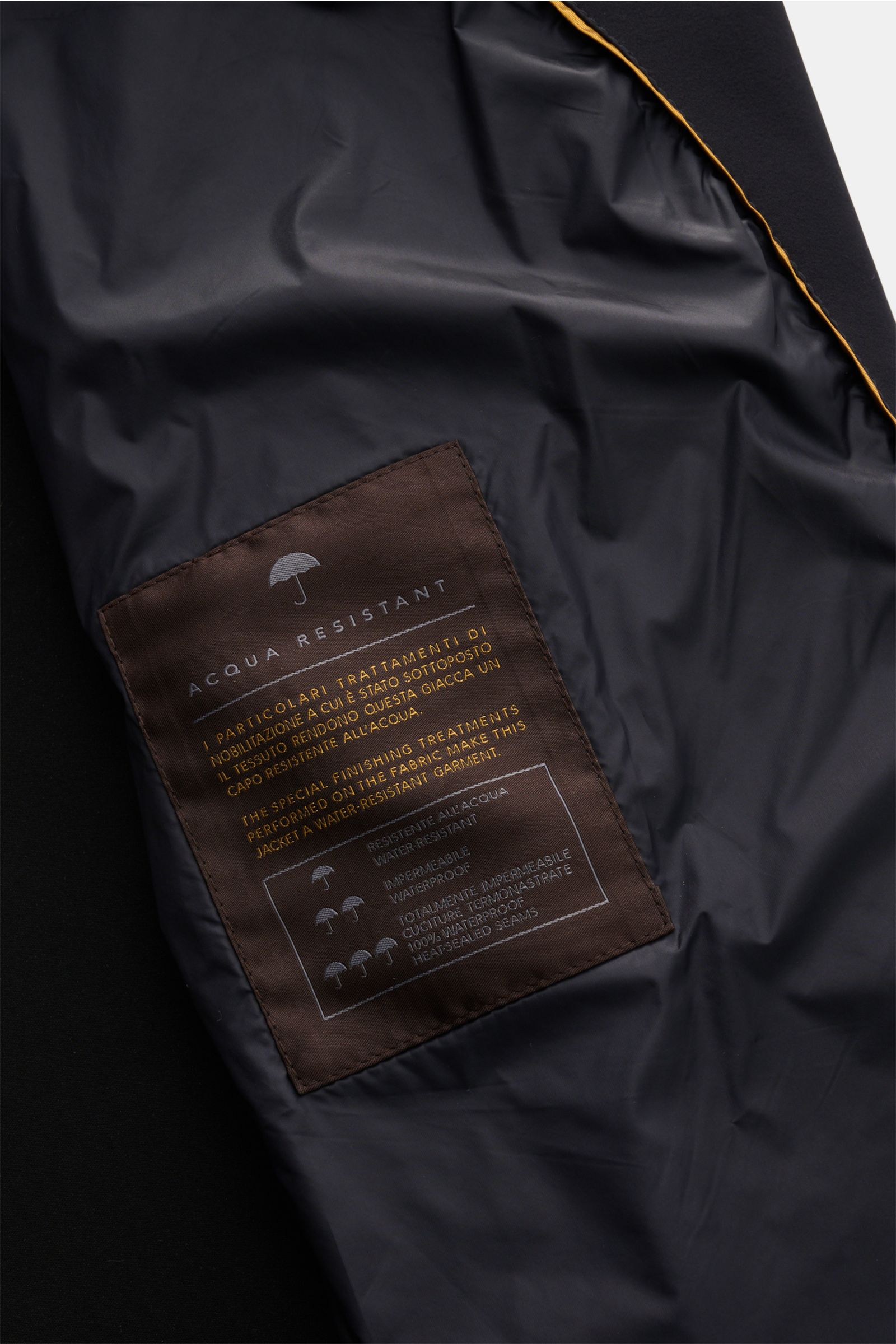 Close-up interior view of the Moorer Kurzmantel 'Vittor' dark navy showing water-resistant fabric label and smooth lining. Souveräne Eleganz für jeden Tag: Der leichte Mantel 'Vittor' überzeugt mit seiner hochwertigen, wasserabweisenden Microfaser. Hal