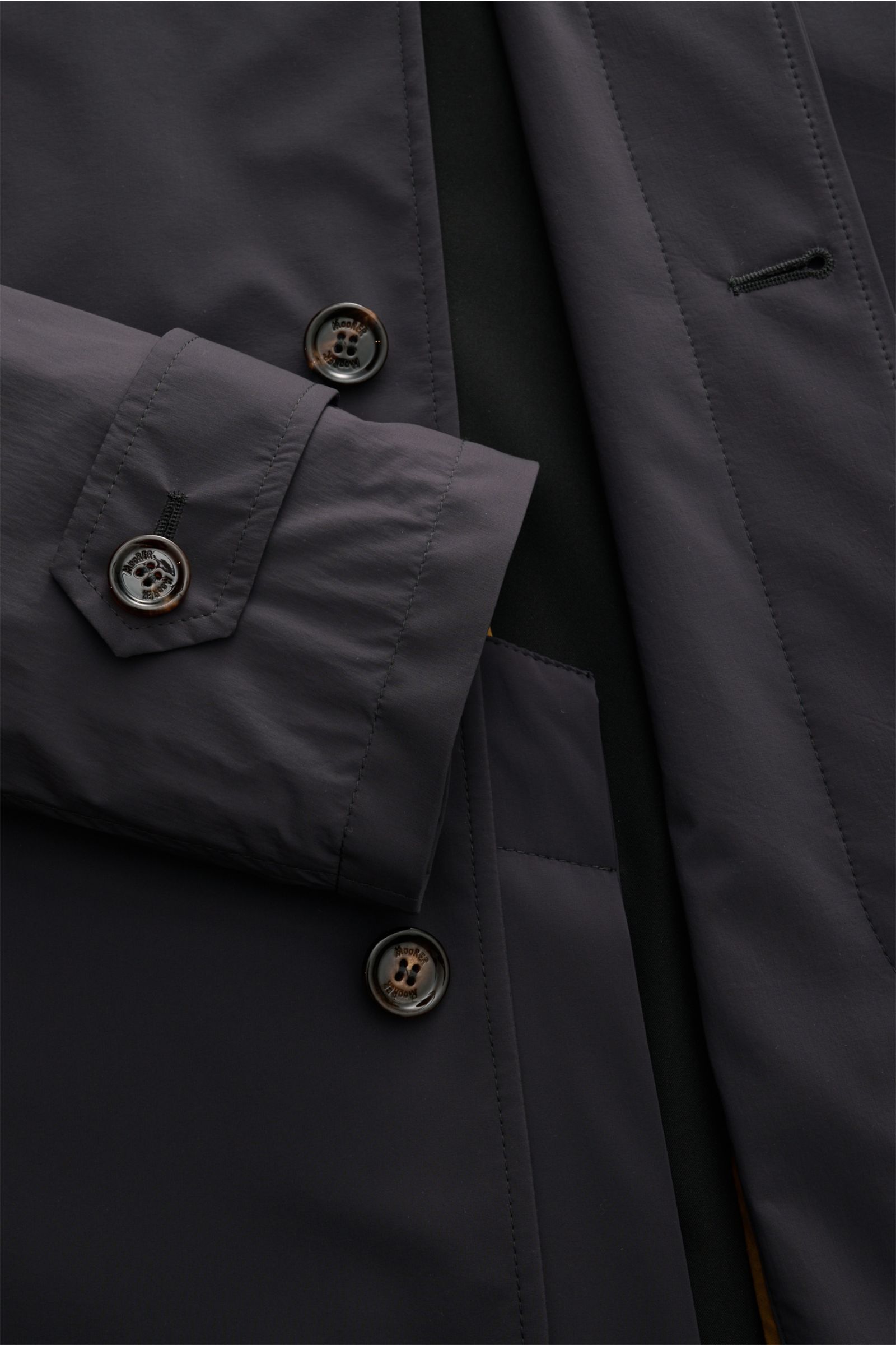 Close-up front view of Moorer Kurzmantel 'Vittor' dunkelgrau in dark grey showing water-repellent microfiber fabric, slim fit, four-button placket, turn-down collar, piped front pockets, buttoned sleeve cuffs, back vent, smooth lining, and inner pocket. E