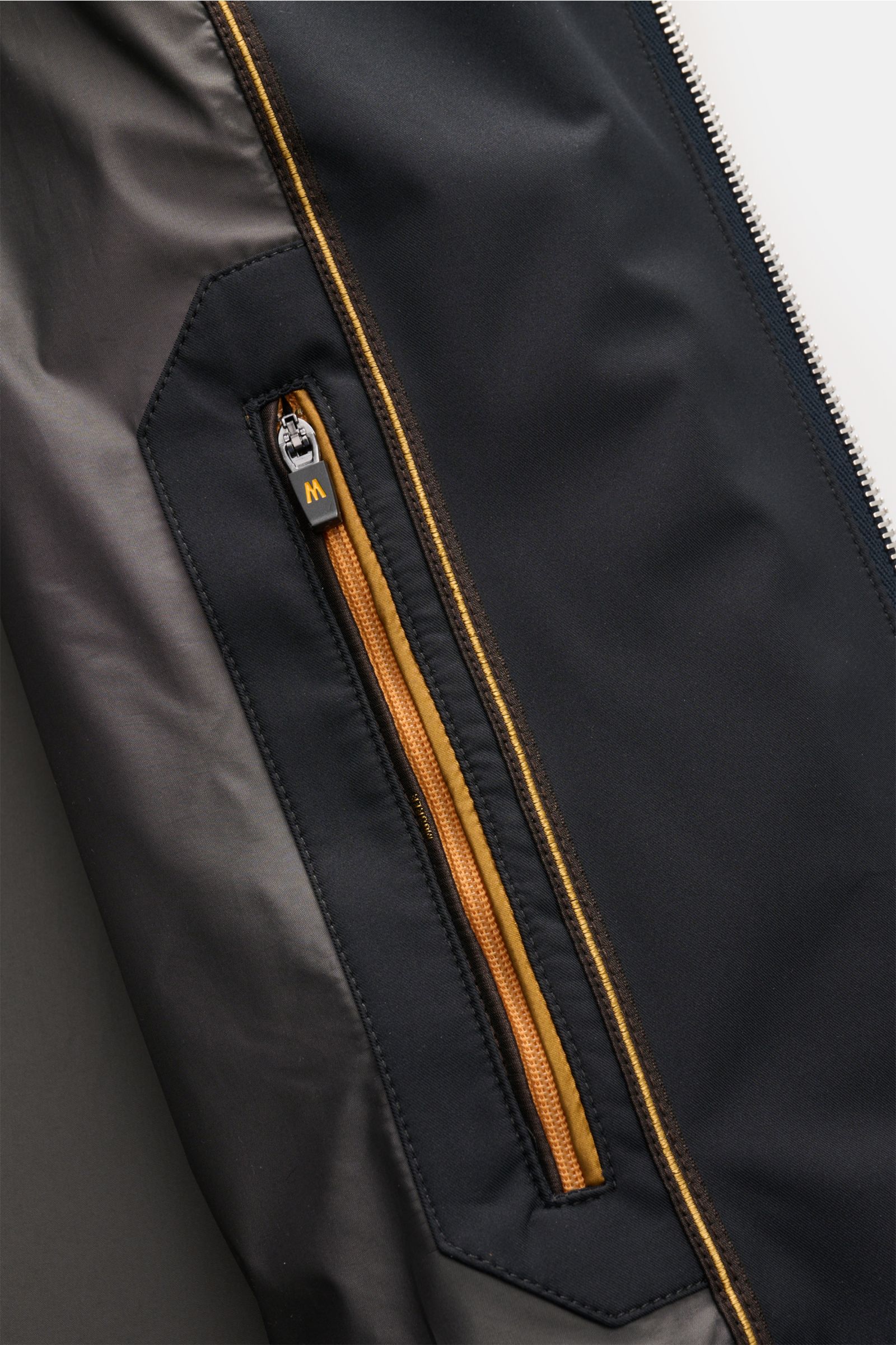 Close-up inside view of Moorer Short coat 'Tiglio' dark navy showing waterproof fabric, smooth lining, and zipped inner pocket with contrasting trim.