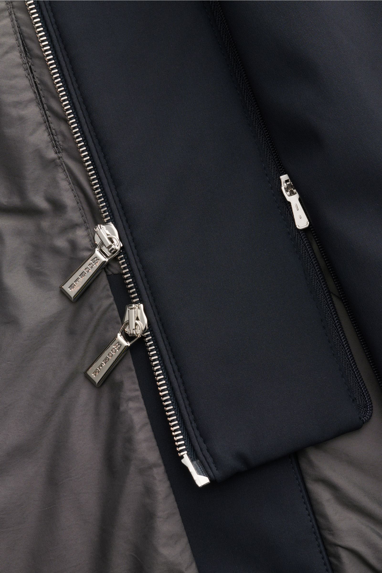 Close-up image of the inside and front zipper detail of the Moorer Jacket 'Borromeo' navy, showing the smooth lining and two-way zip from a top-down perspective. With its water repellent finish and clean look with double front, the jacket 'Borromeo' by MO