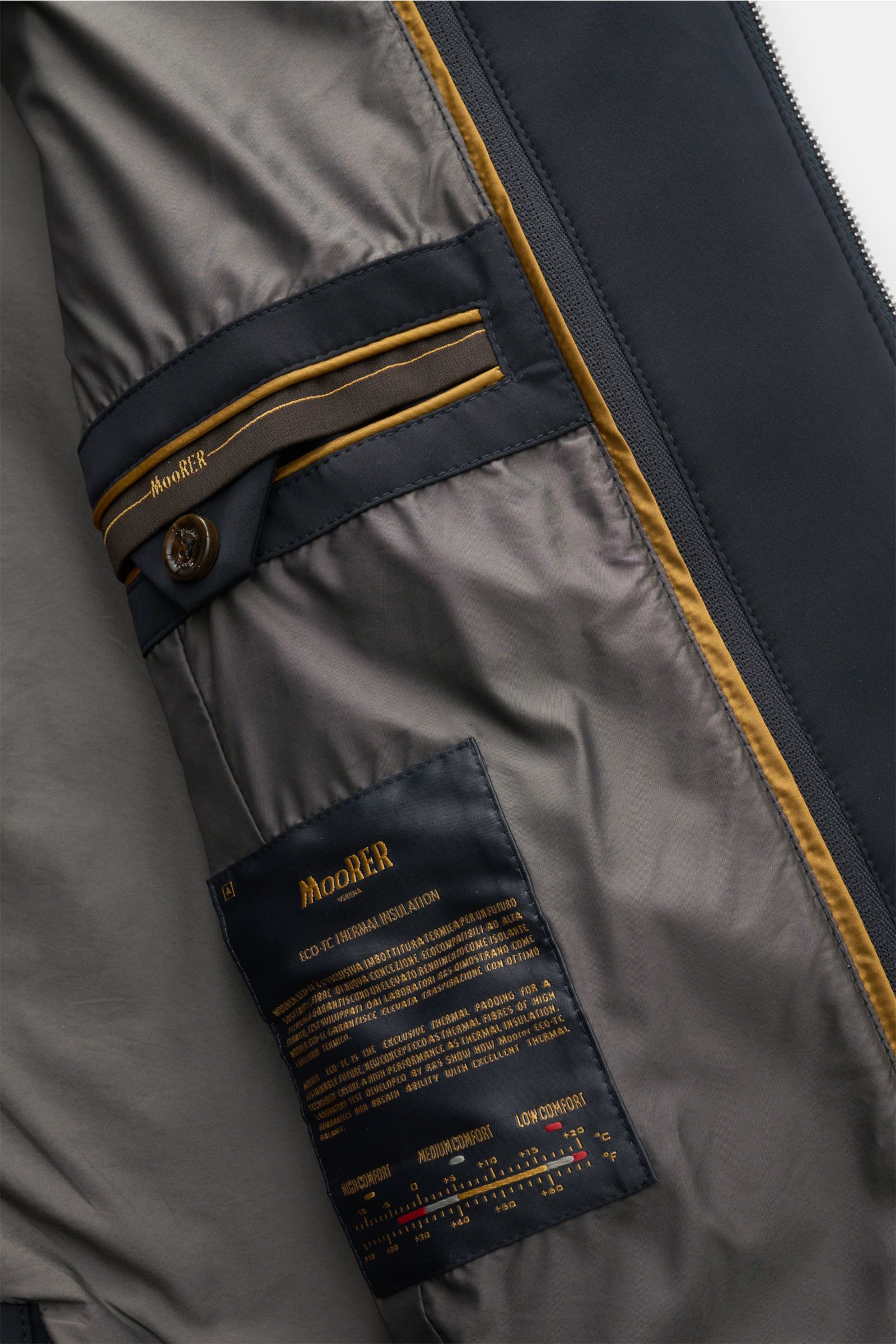 Close-up interior view of the Moorer Jacket 'Borromeo' navy, showing smooth lining, inner pocket with button and detailed label. With its water repellent finish and clean look with double front, the jacket 'Borromeo' by MOORER is the perfect city player a