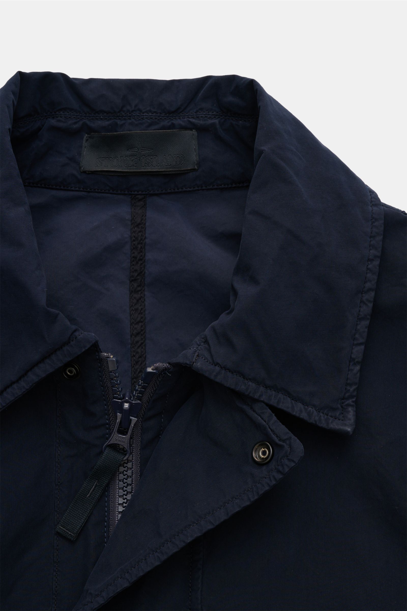 Nahaufnahme des Kragens von Stone Island Mantel 'Ghost Piece' navy aus der Ghost-Collection, leichte Microfaser, wasserabweisend.
