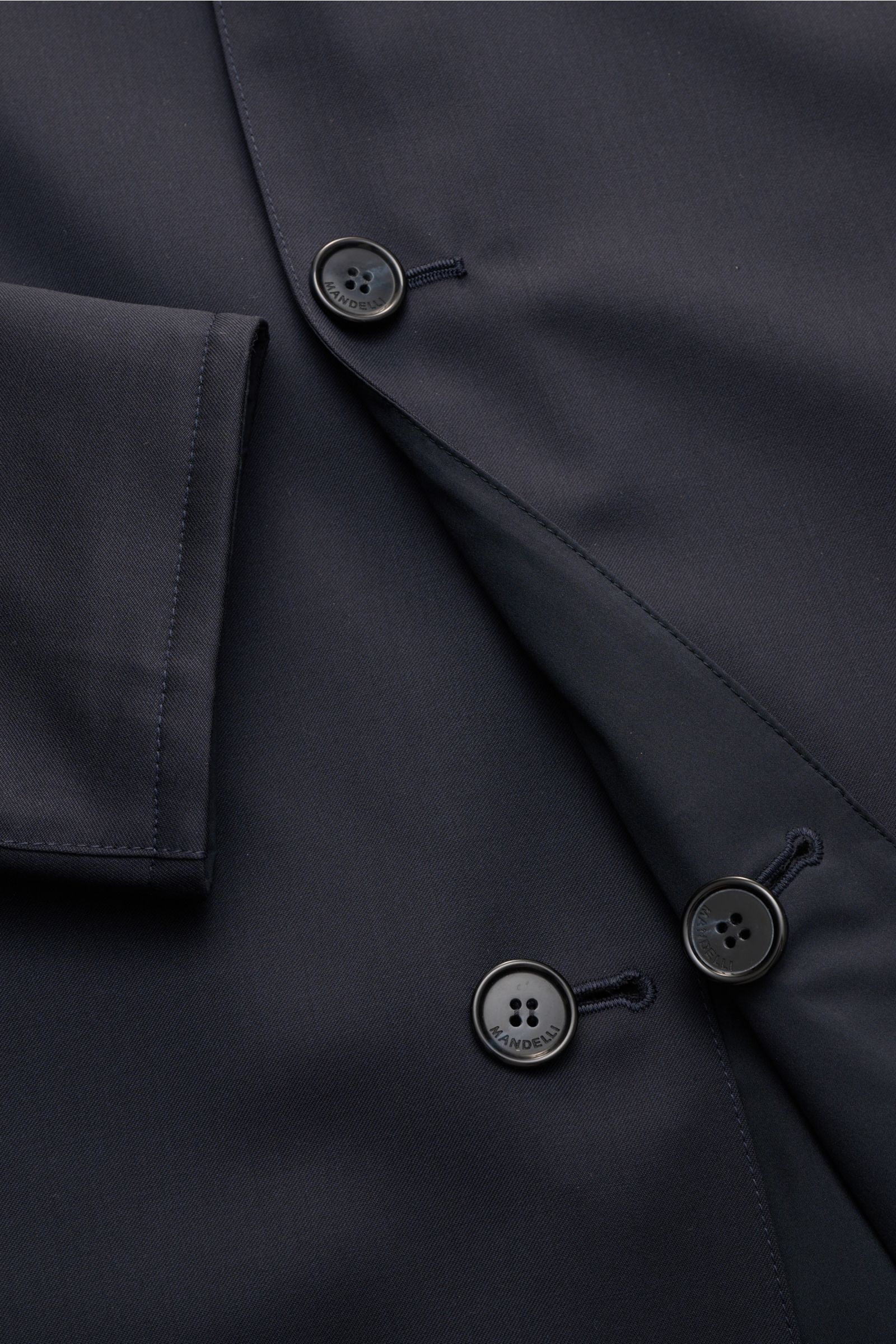 Nahaufnahme des Mandelli Wende-Kurzmantels navy aus reiner Wolle mit Slim Fit, Vier-Knopf-Leiste, Umlegekragen und paspelierten Taschen.