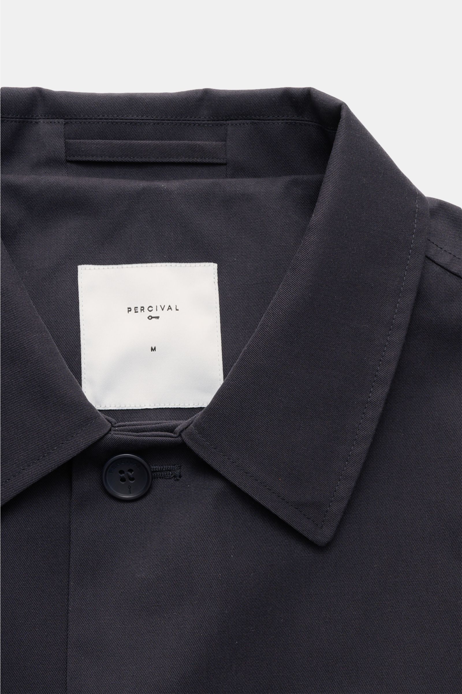Close-up front view of the collar and top button of the Percival Kurzmantel 'Sherlock' dark navy, made from durable twill fabric with a laminated membrane, featuring a regular fit, five-button placket, and unconstructed design.