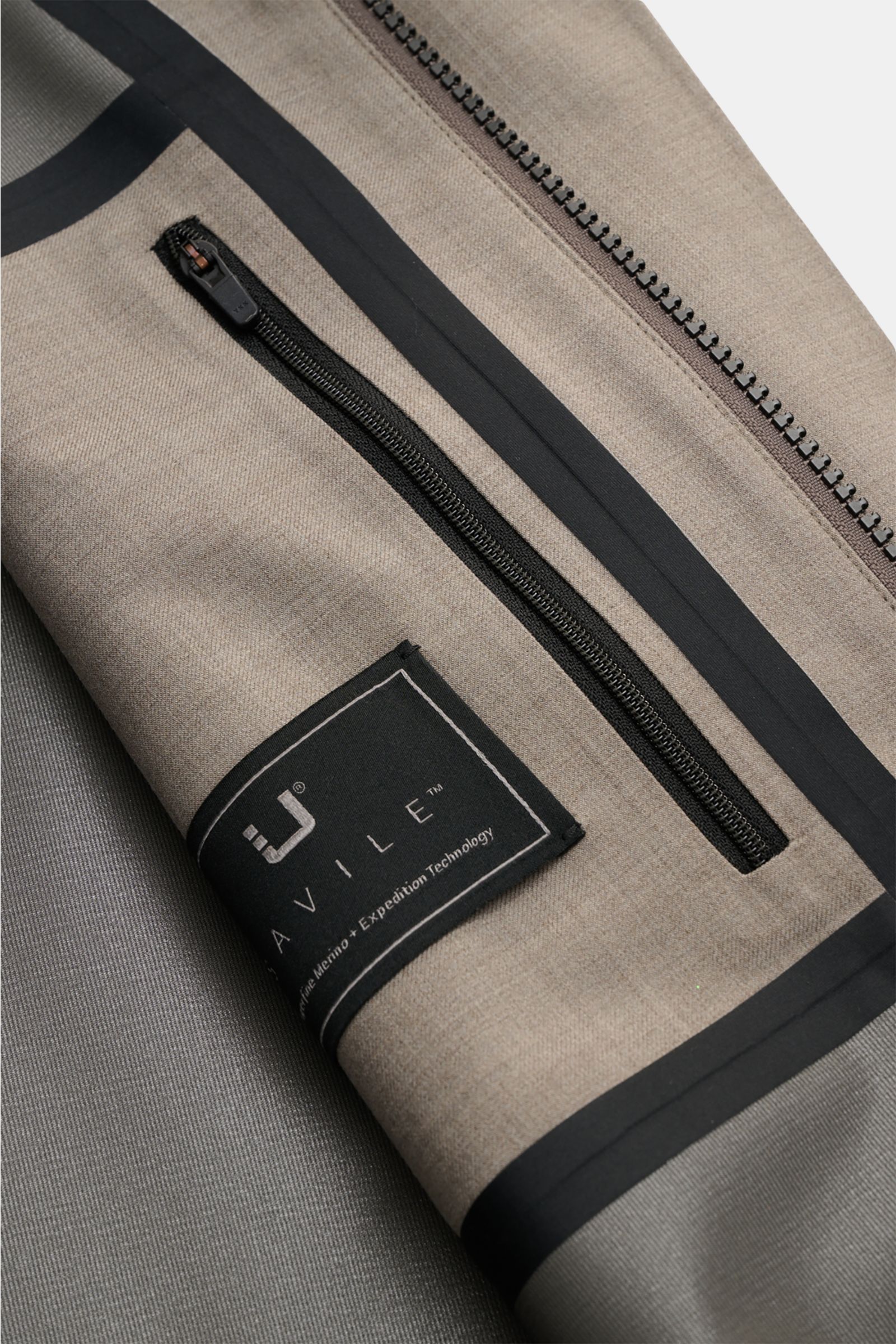 Close-up inside view of UBR Rain coat 'Sky Fall Savile' taupe mottled showing zipped inner pocket, taped seams, and fabric texture.

The incredibly lightweight rain coat 'Sky Fall Savile' by UBR is made of smart merino wool and microfibre for effortles