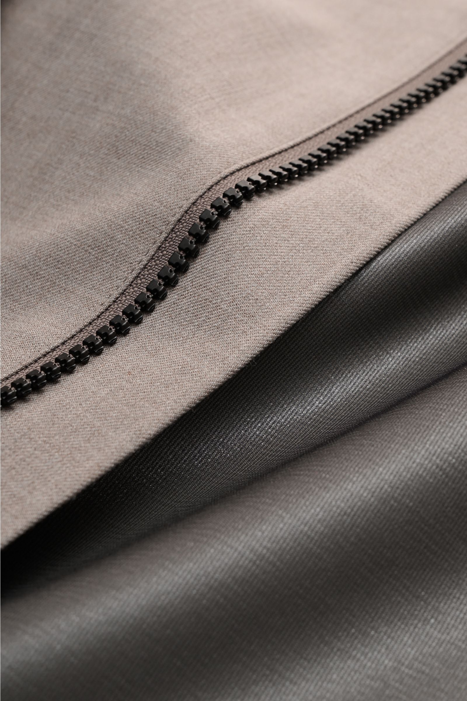 Close-up detail of the black zipper on taupe mottled fabric of UBR Rain coat 'Sky Fall Savile' from above, showing texture.

The incredibly lightweight rain coat 'Sky Fall Savile' by UBR is made of smart merino wool and microfibre for effortless protec