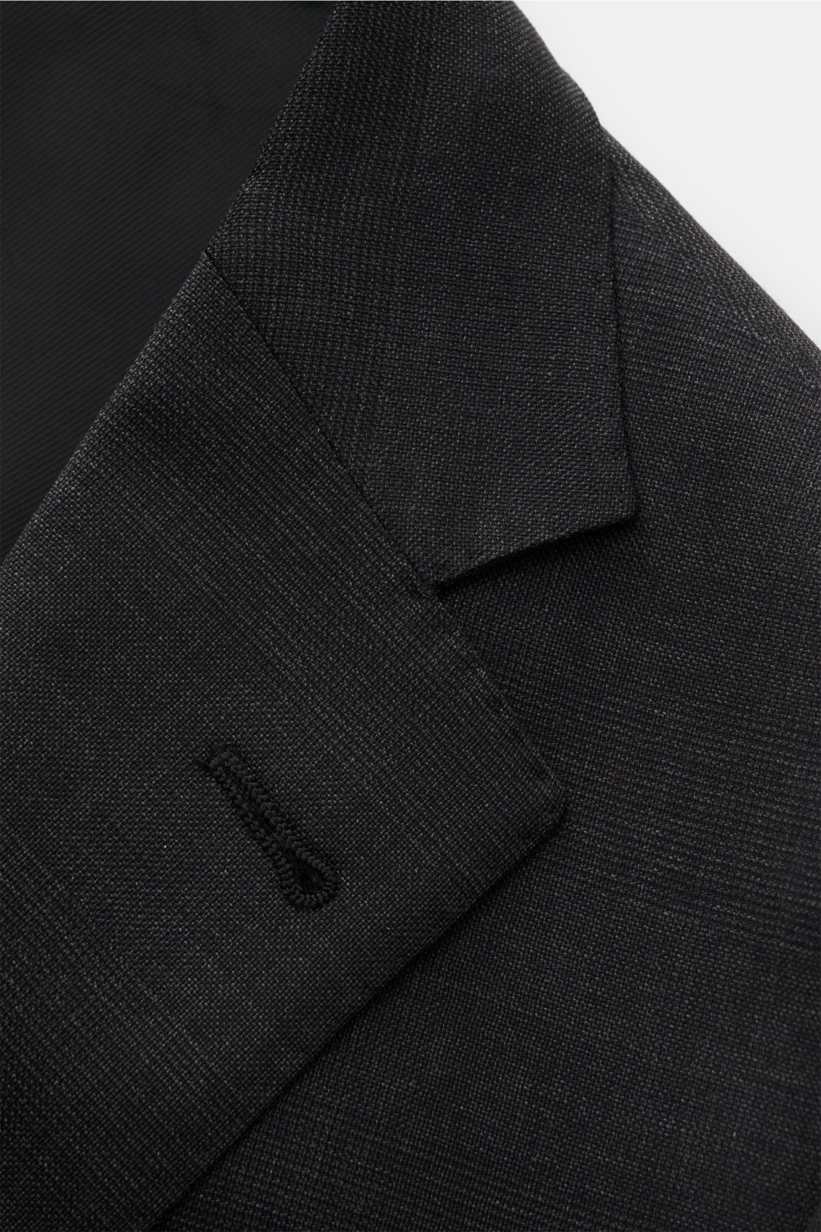 Corneliani Anzug anthrazit meliert close-up from above shows the textured lapel and buttonhole in pure virgin wool with light structured feel and fine weave.


