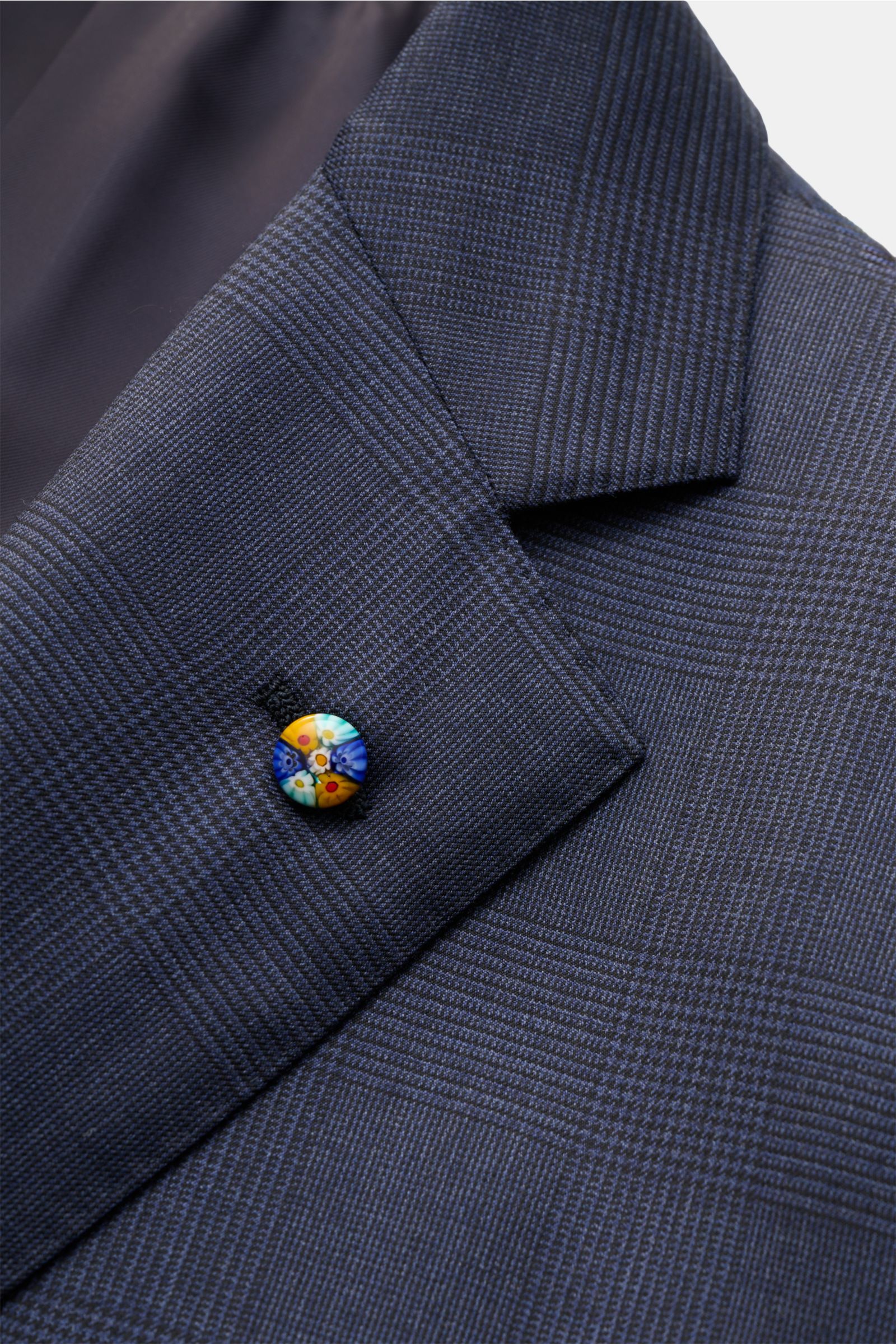 Close-up front view of the Belvest Anzug graublau meliert/schwarz kariert jacket lapel in classic Glencheck wool with a colorful button, showcasing fine tailoring and soft fabric.