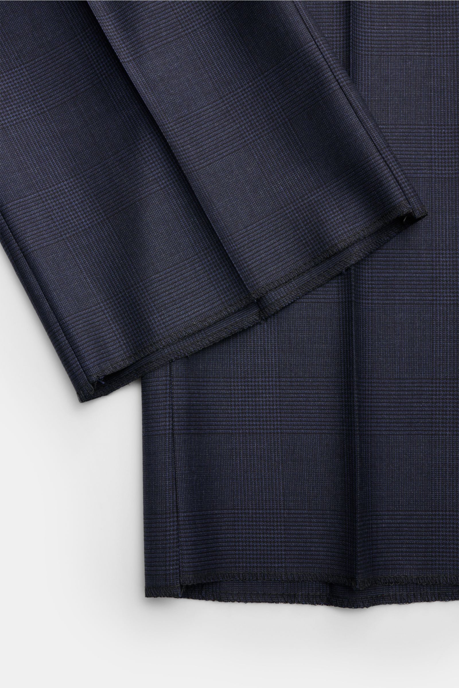 Belvest Anzug graublau meliert/schwarz kariert shown in close-up from above, highlighting the fine Glencheck wool fabric, soft texture, and unfinished sleeve hems. Klassische italienische Eleganz: Der Anzug von BELVEST aus feinster Wolle im edlen Glenchec