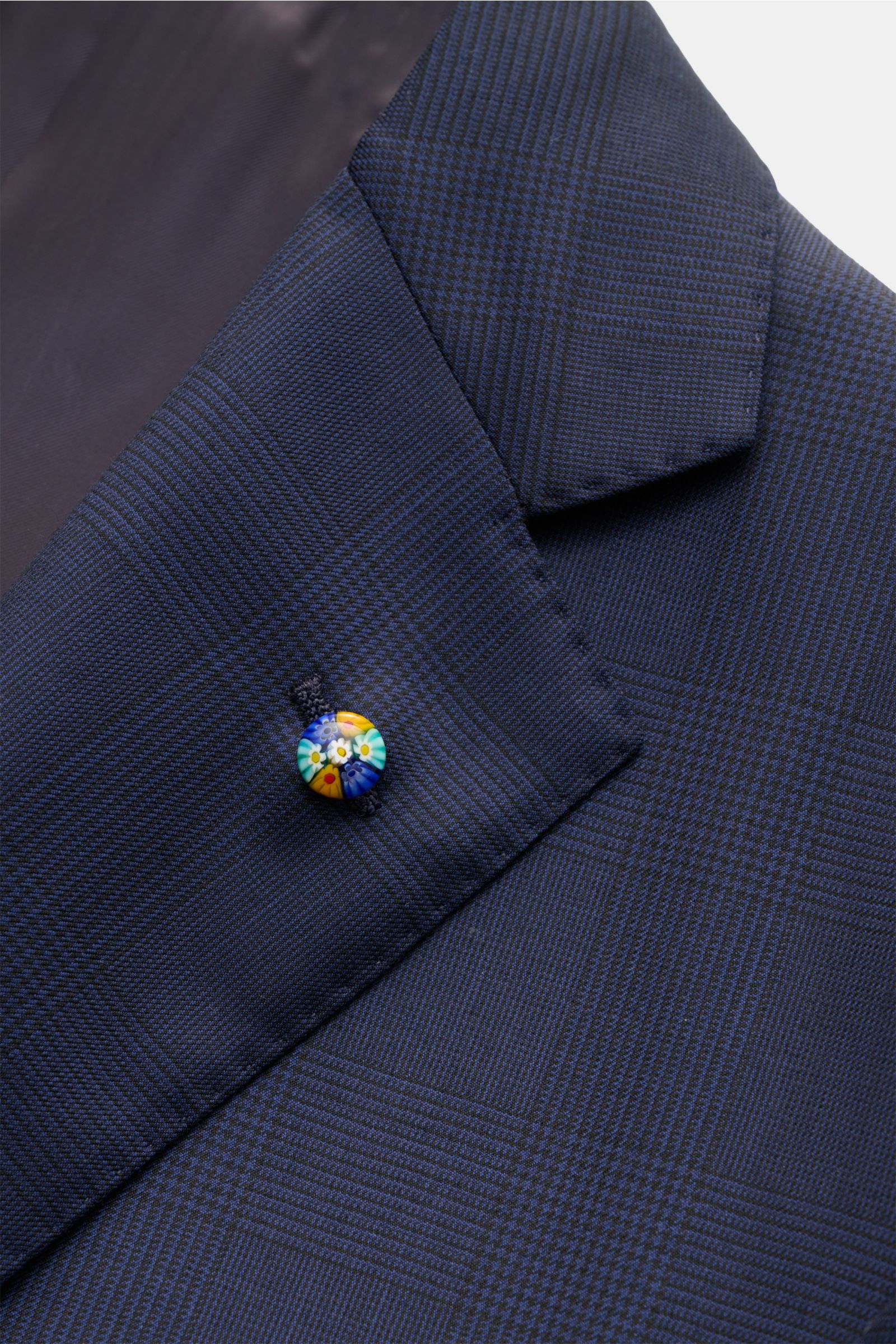 Close-up front-left view of Belvest Anzug dunkelblau/schwarz kariert in fine Glencheck wool, featuring a slim fit, two-button jacket with floral pin.