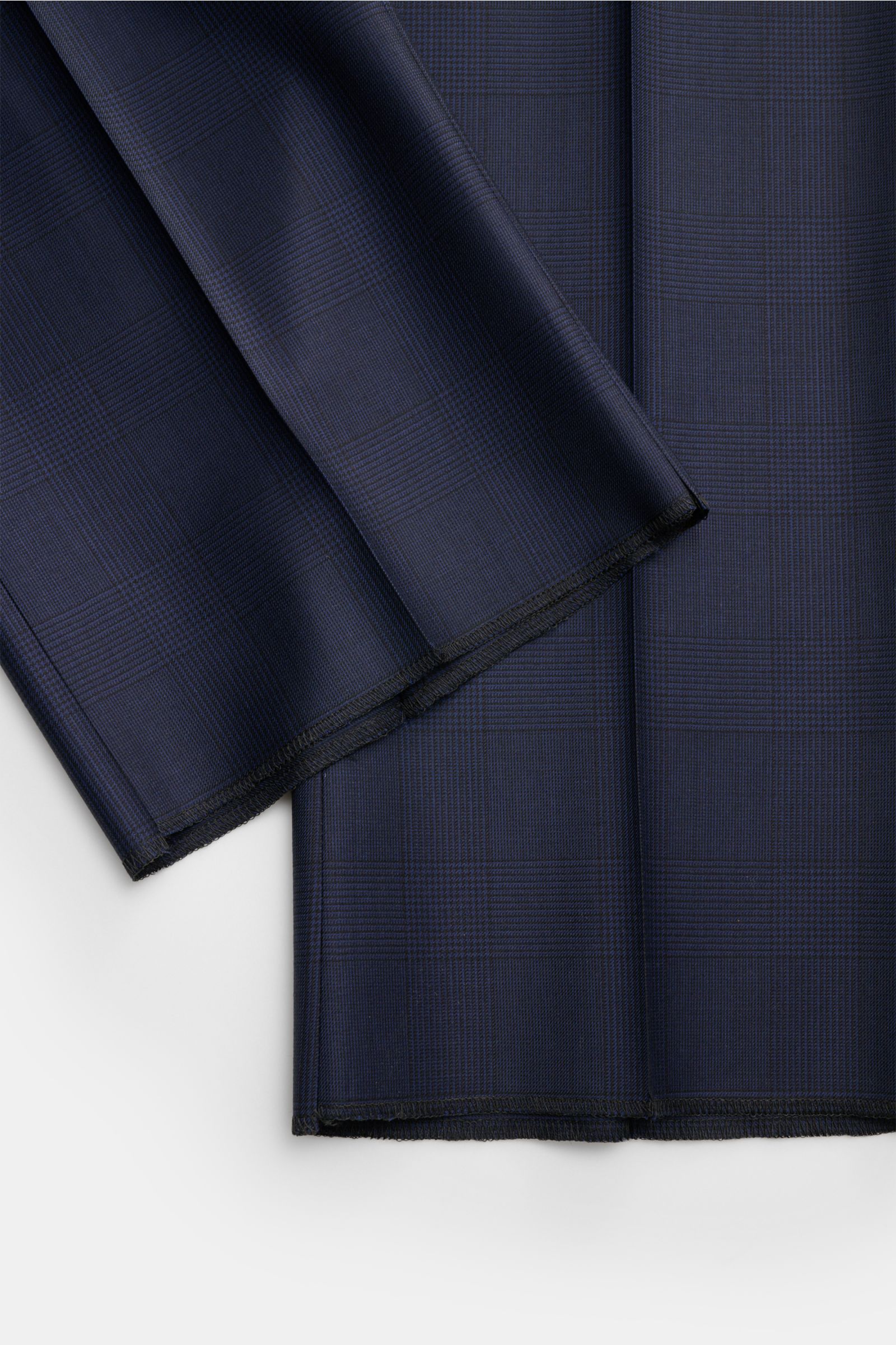 Close-up top-down view of dark blue and black Glencheck fabric for Belvest Anzug dunkelblau/schwarz kariert, showcasing fine wool texture and classic pattern. Klassische italienische Eleganz: Der Anzug von BELVEST aus feinster Wolle im edlen Glencheck-Des