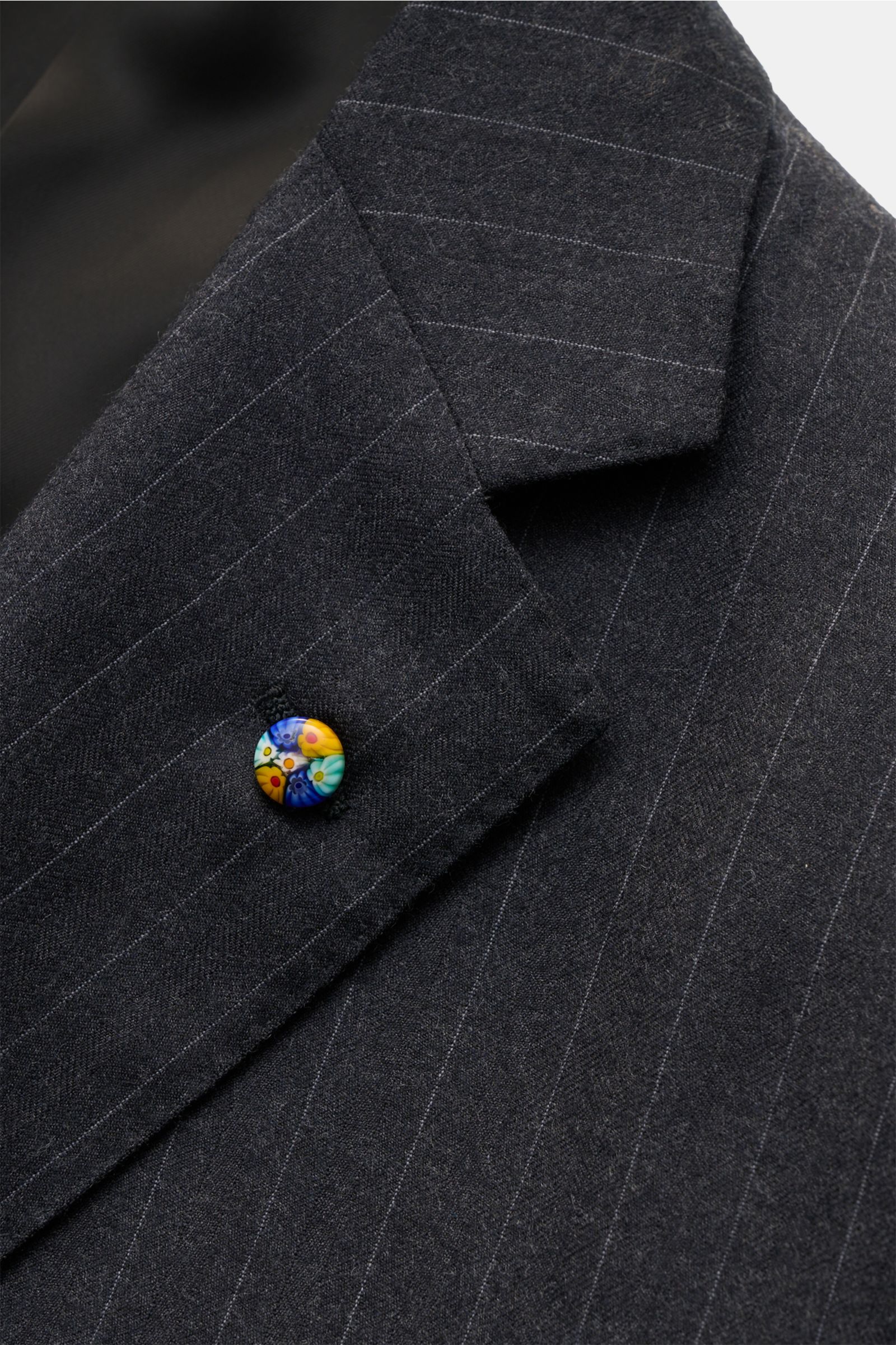 Close-up view of the lapel of the Belvest Anzug navy/grau gestreift, a classic Italian slim-fit wool suit with subtle pinstripes and a colorful floral lapel pin, showcasing fine fabric texture and tailored details.