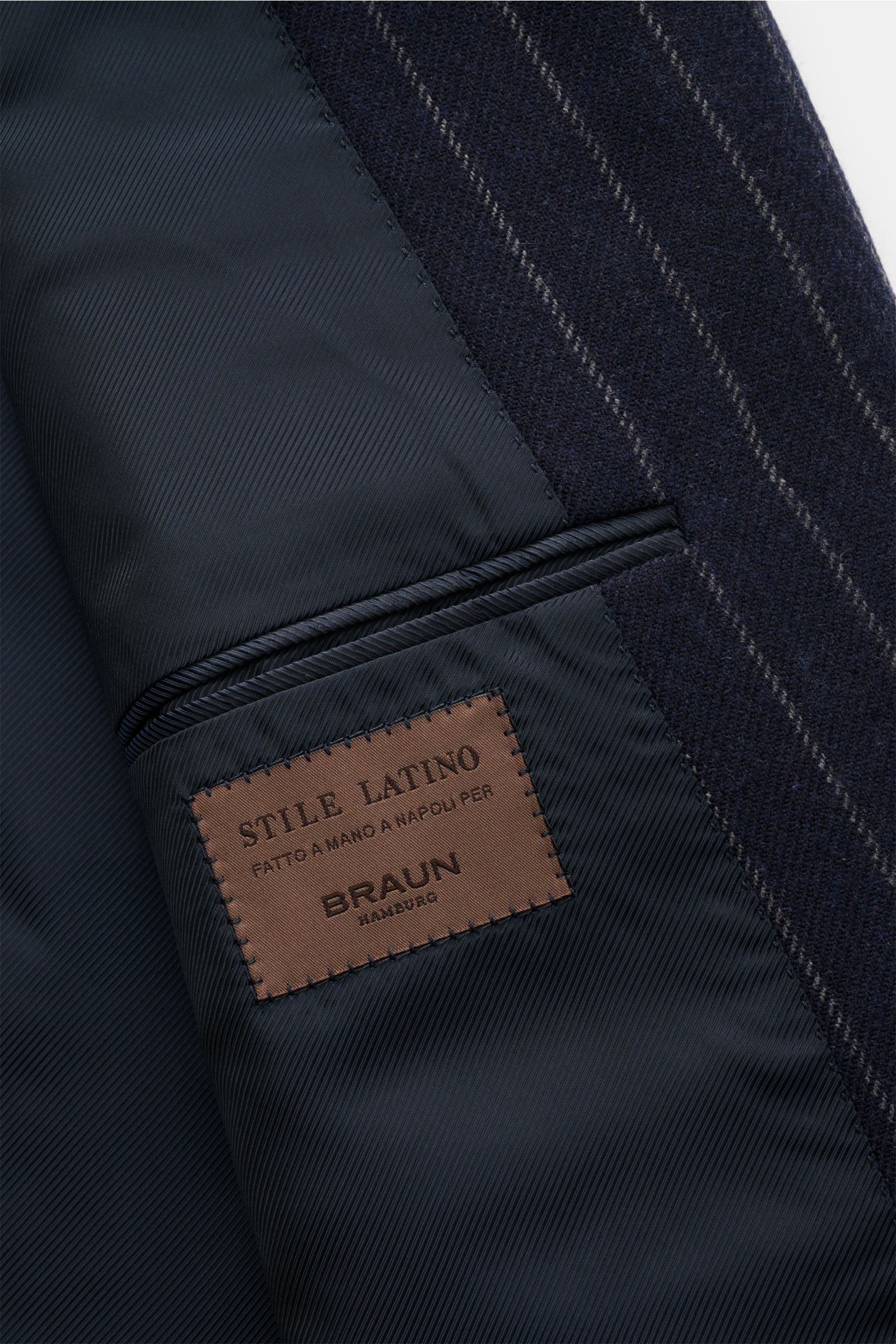 Innenansicht des Stile Latino Anzugs 'Andrea' navy/grau gestreift mit feinem Futter und Label, Detailaufnahme von Sakko und Taschen.