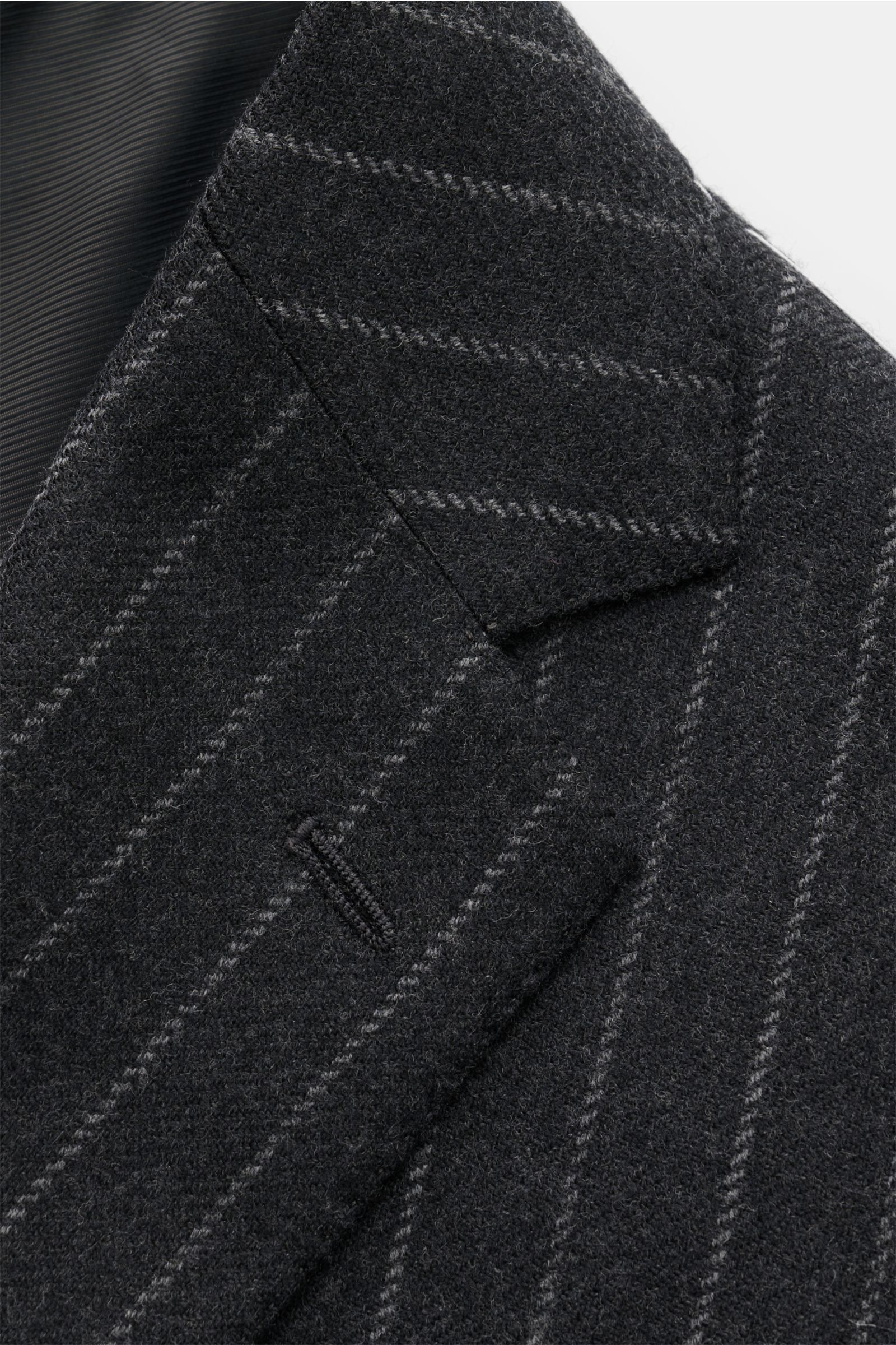 Nahaufnahme des Stile Latino Anzugs 'Vincenzo' anthrazit/grau gestreift von schräg oben, zeigt das taillierte Drei-Knopf-Sakko mit Chalk Stripes aus Woll-Viskose-Mix.