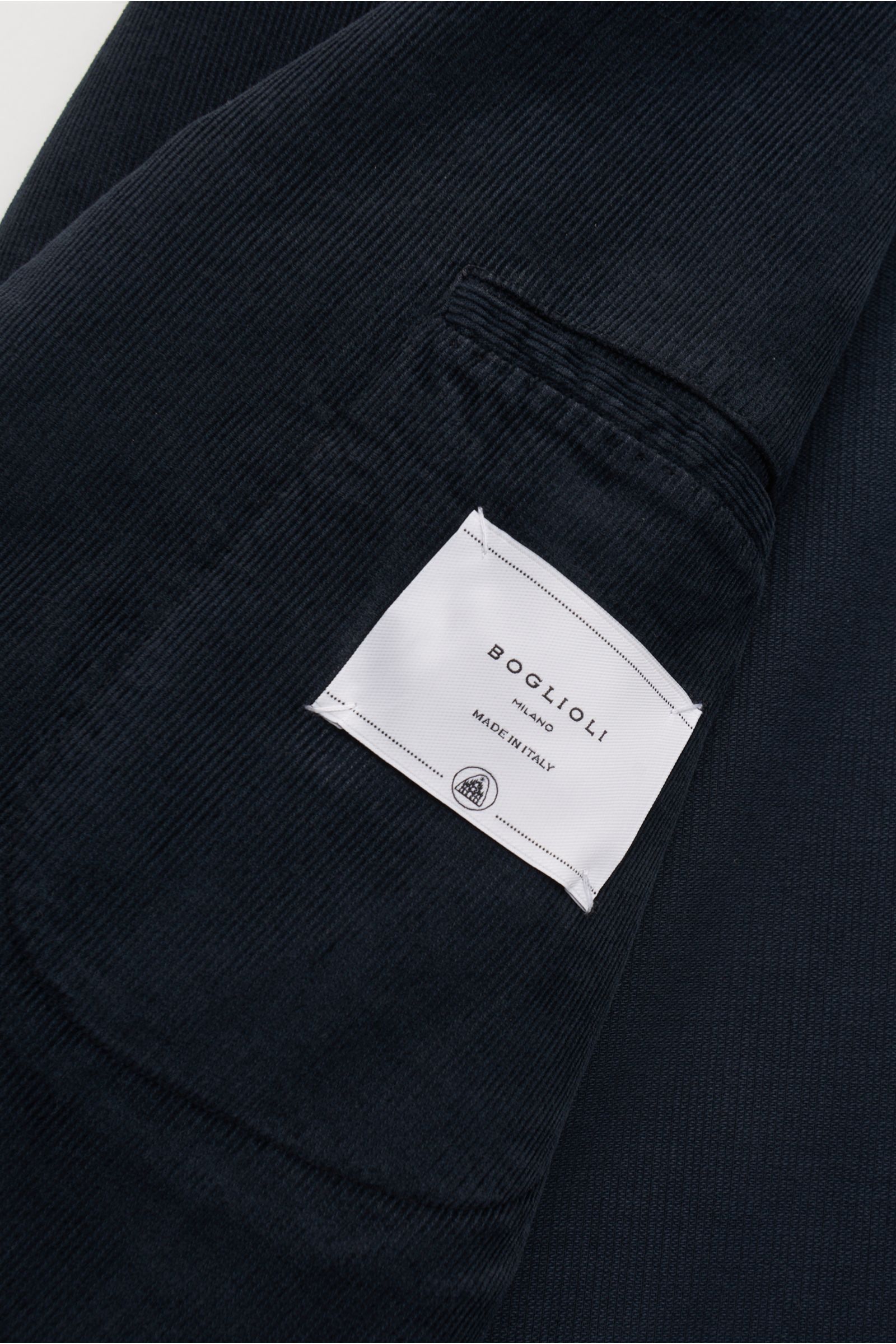 Close-up view of the navy corduroy fabric and inner label of the Boglioli Cord Anzug 'K. Jacket' navy, showing fine texture. Leichtes Unconstructed-Design auf italienische Art: Der stilvolle 'K. Jacket' Anzug aus feinem Cord von BOGLIOLI besteht aus einem